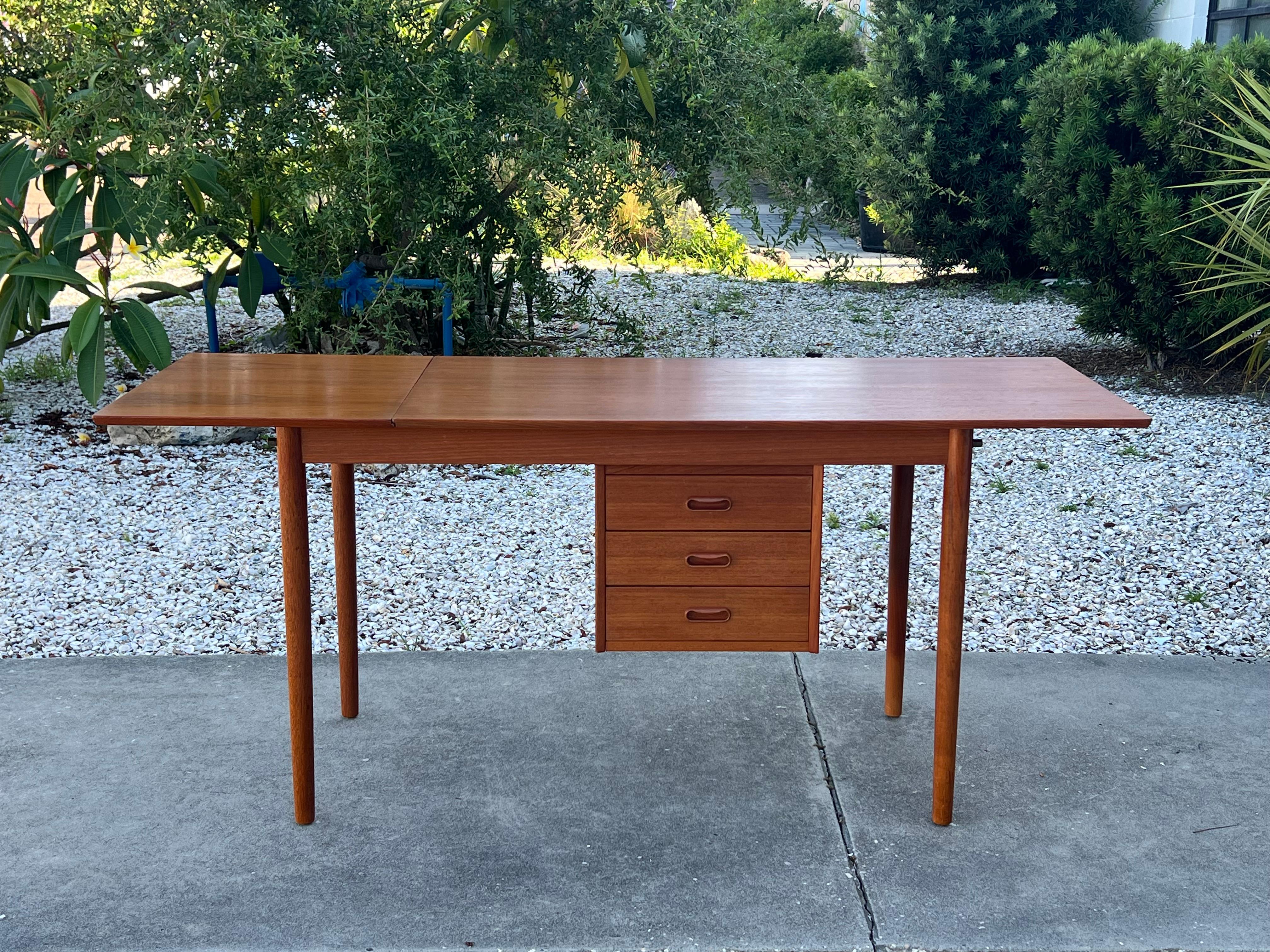 A classic Arne Vodder for H.Sigh and son desk with drop-leaf and sliding rails-allowing the drawers to be on either side. Vintage circa 1960s with nice rich patina. The leaf hangs from two brass hooks and is removable. To use the leaf, it is raised,