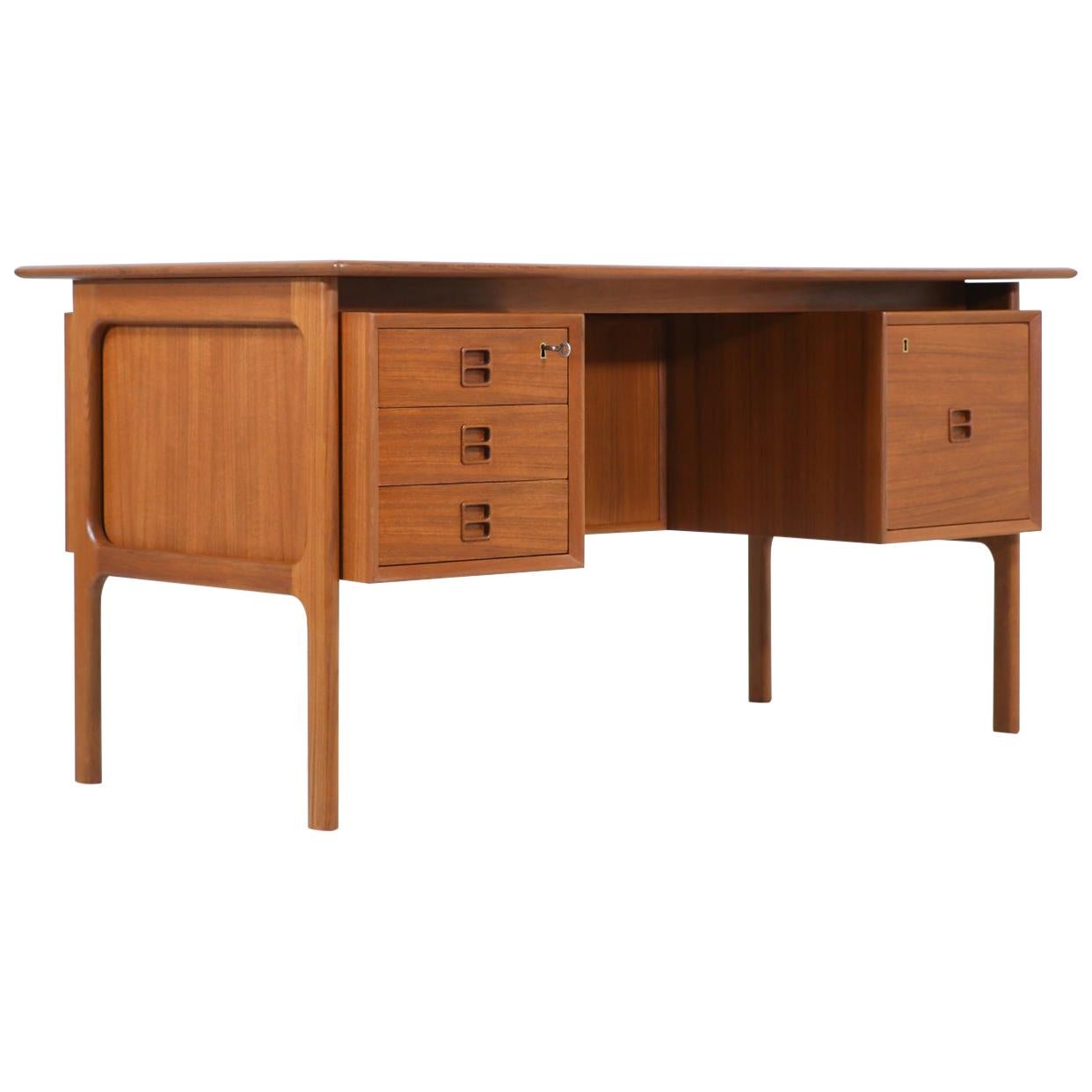 Elegant modern executive desk designed by Erik Brouer for Brouer Møbelfabrik in Denmark circa 1950s. This striking design features a teak wood frame with three spacious drawers on its left side and a large filing drawer on its right side. Its best