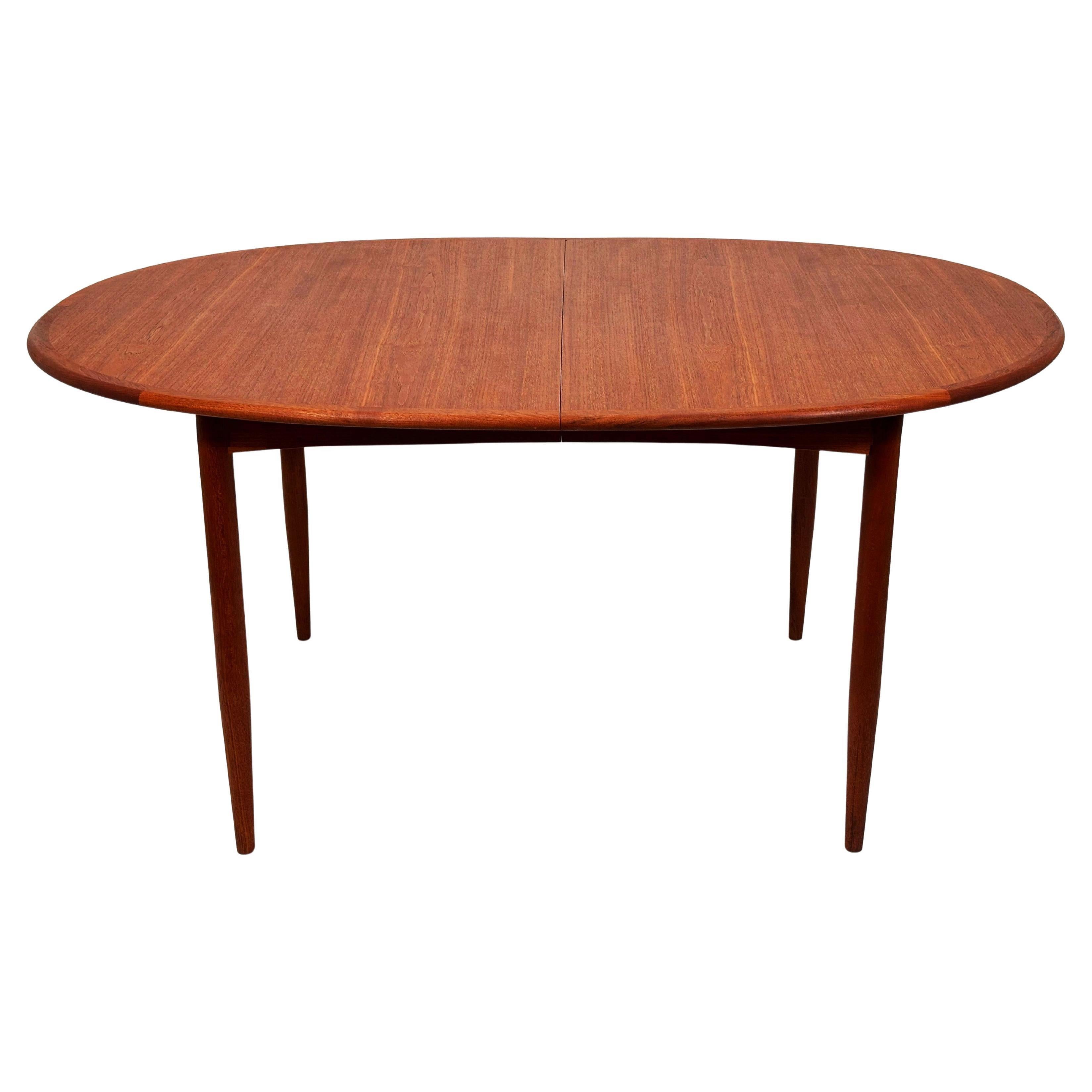 Beautiful teak dining table designed by Arne Vodder, Denmark, 1960s. Classic soft-oval top, tapered legs, and exceptional teak grain. Two original leaves, allowing the table to expand for larger gatherings.

Condition: Excellent vintage condition