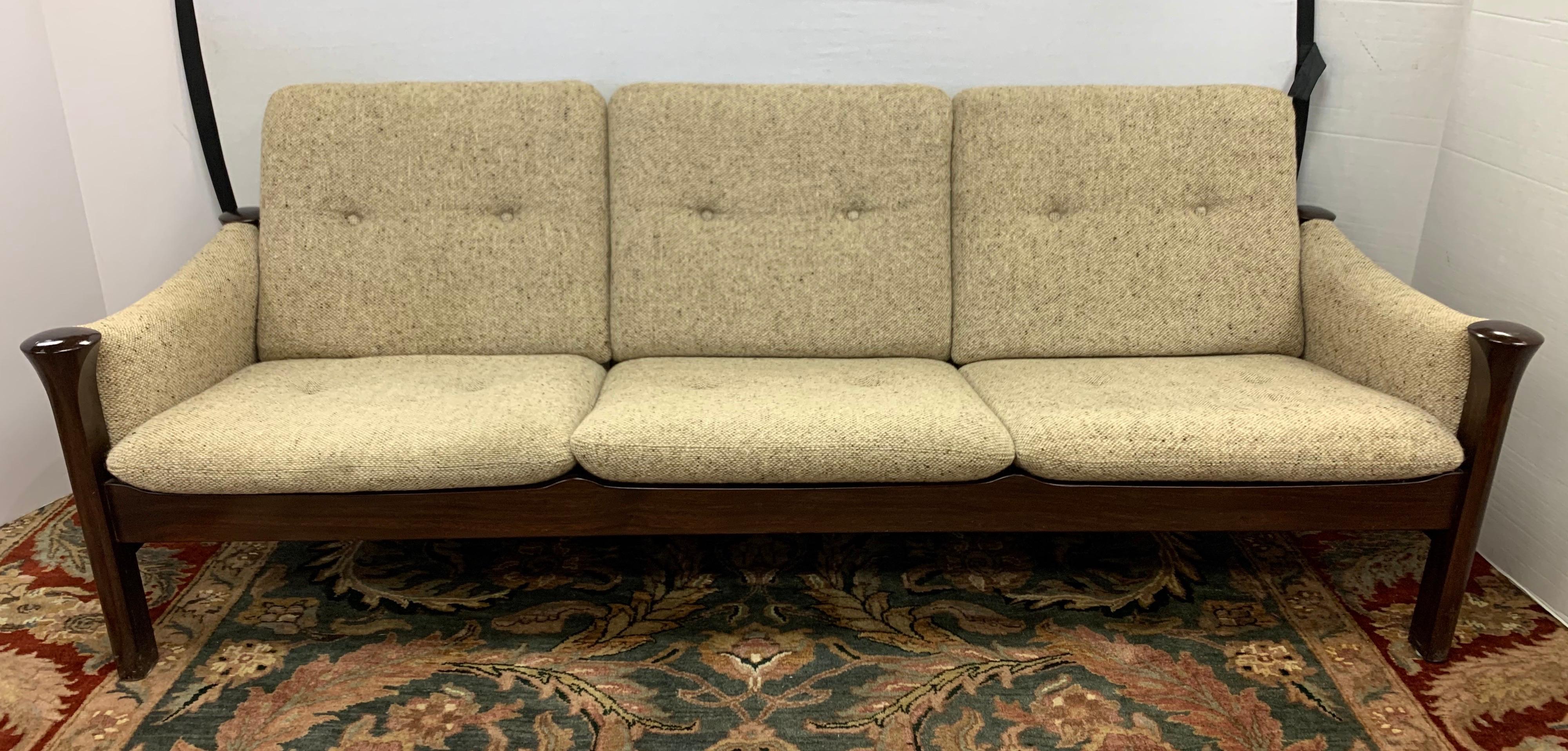 With its plinth shaped legs, bar reclining back, oatmeal tweed upholstery, and incredible lines, this signed Cado three-seat sofa by Arne Vodder is nothing short of exceptional. Made in Denmark and all original, it is still in great condition. An