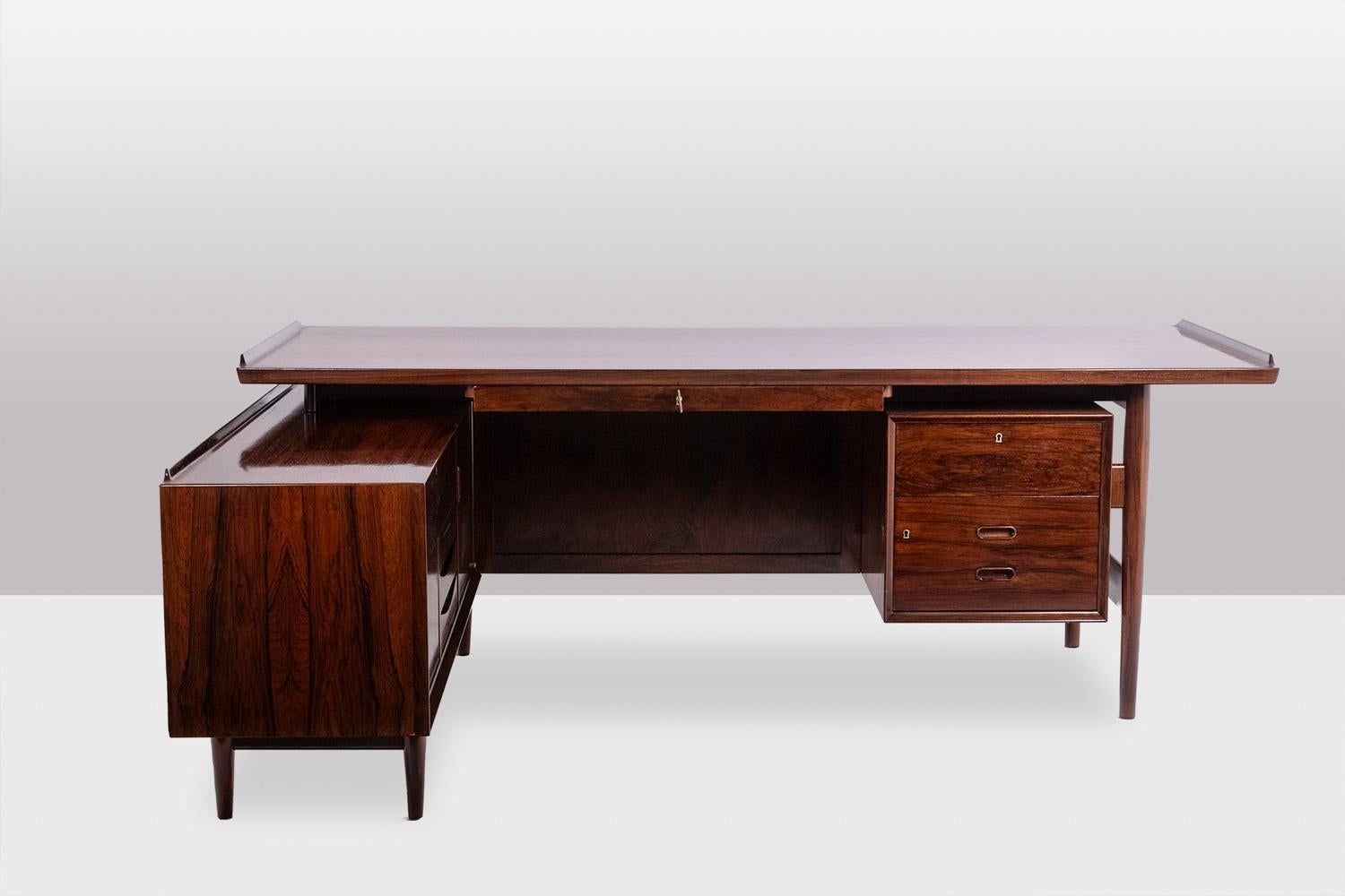 Arne Vodder for Sibast.

Corner desk in rosewood, opening on the front with a box with three drawers and a large drawer in the central part. Drawers and doors on the left side. Straight base.

Danish work realized in the 1970s.

Dimensions:

Tray: H