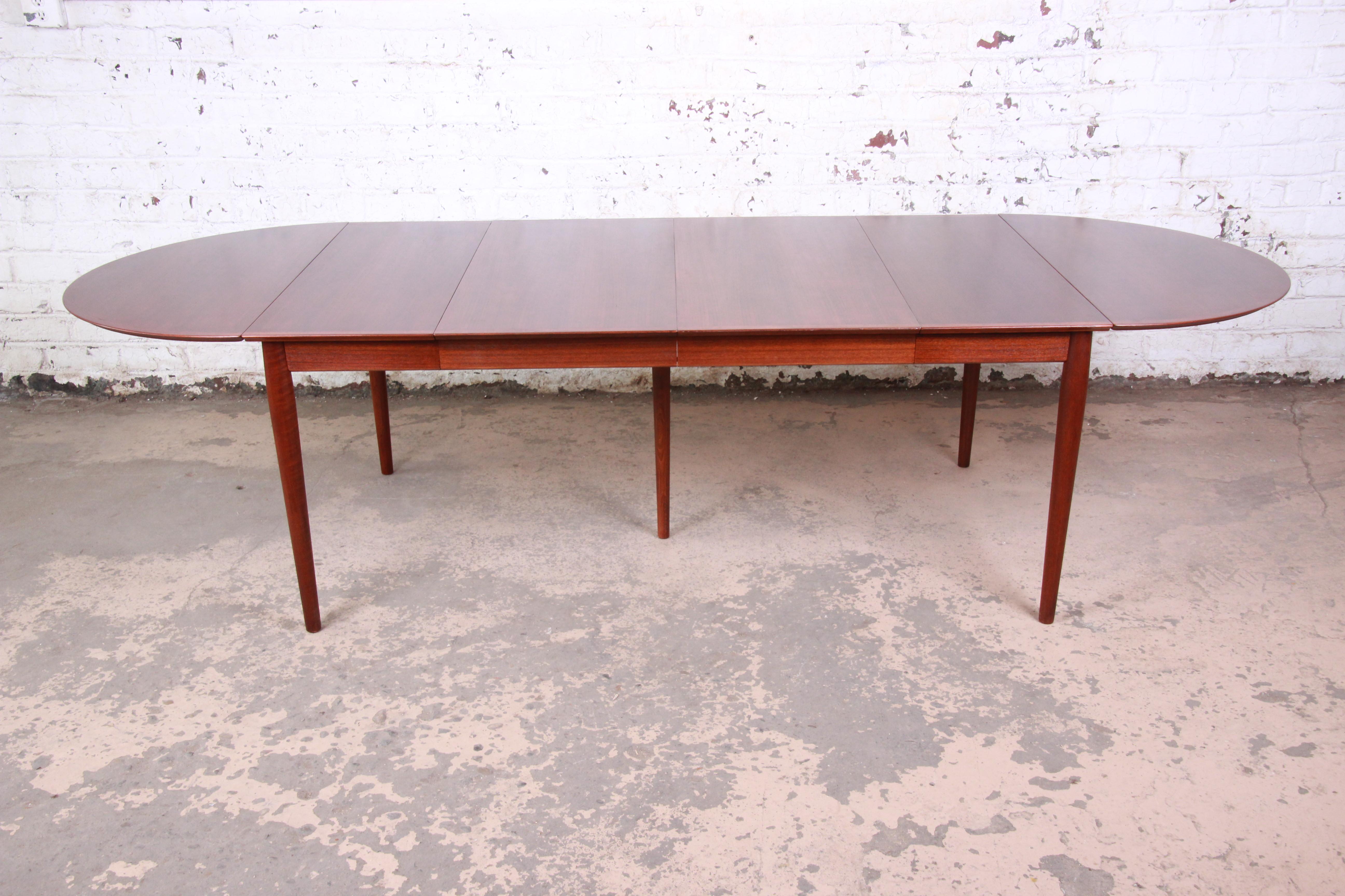 An exceptional Minimalist midcentury Danish Modern teak extension dining table. Very versatile, with drop leaves and two extension leaves.

By Arne Vodder for Sibast Møbler

Denmark, circa 1960s

Measures:
Leaves down with no extensions - 33