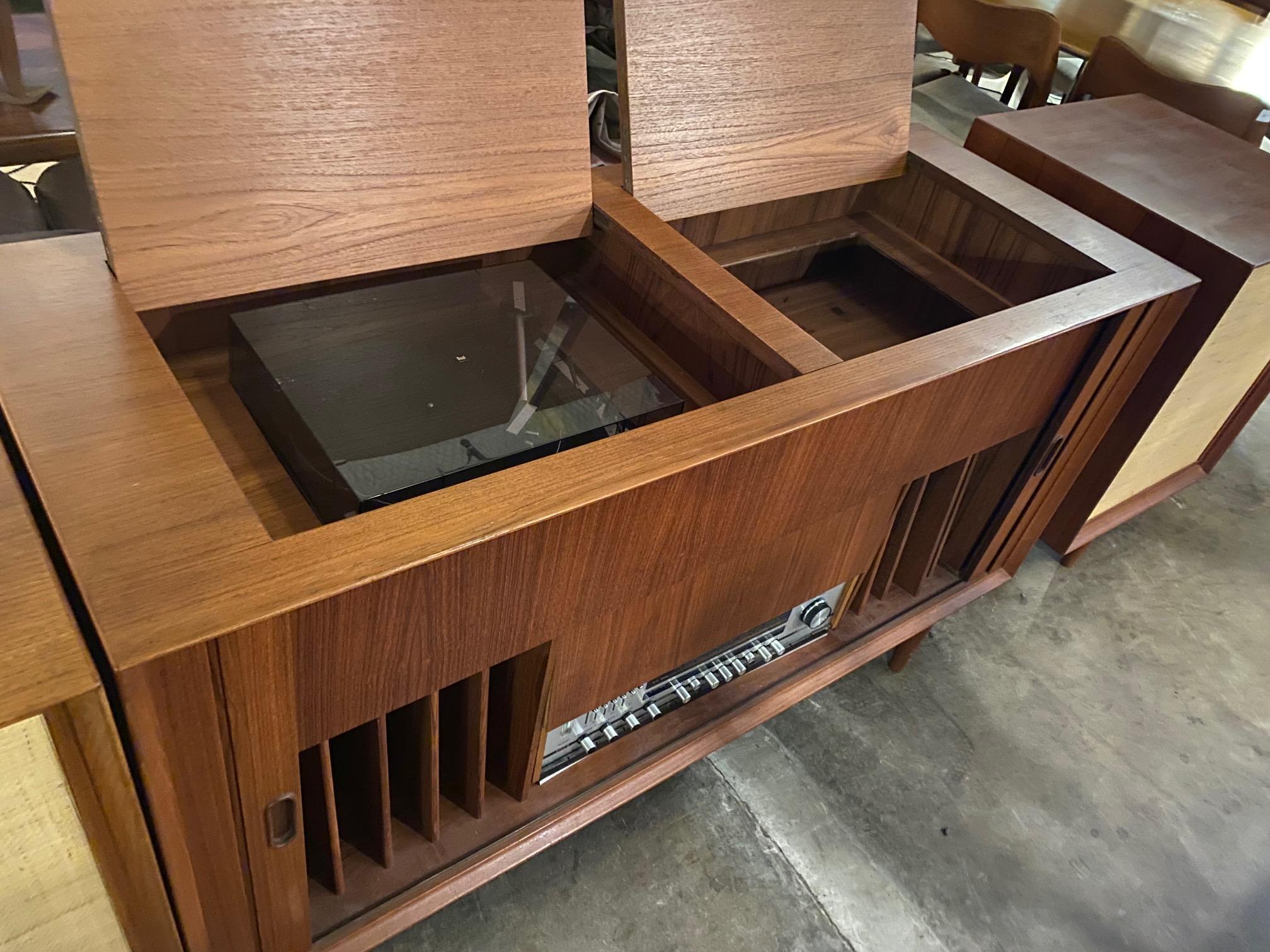 Stunning Danish teak stereo console with tambour doors made by Arne Vodder for Sibast offers speaker cabinets, storage and can be setup with stereo components. Top features drop-in element to accommodate turntable. This vintage mid-century console