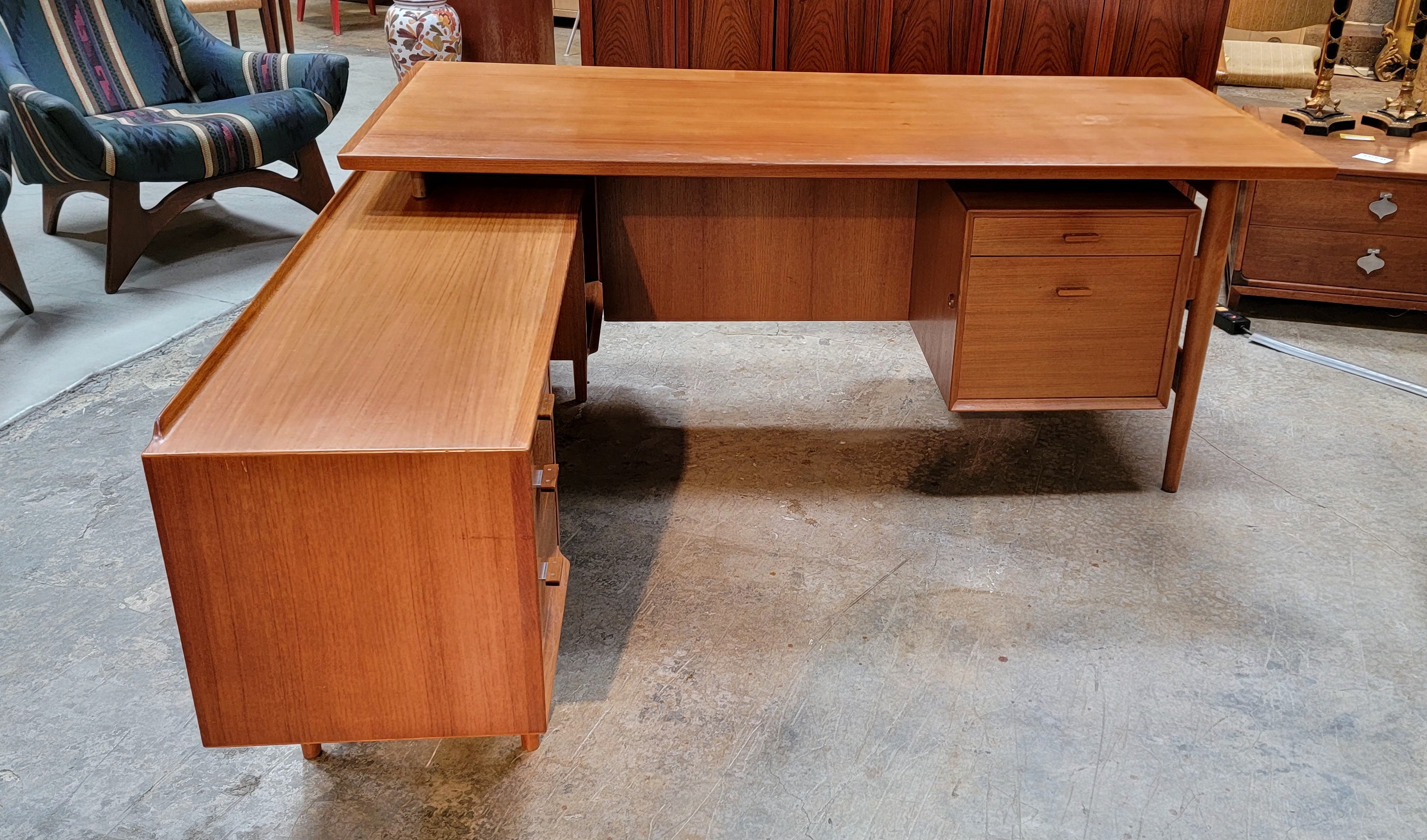 Fine teak Danish Modern L-Shaped executive or work desk designed by Arne Vodder for Sibast, Denmark. Ample leg room for working at desk or credenza. Consists of 5 drawers, one being a file drawer. Open storage on right side of credenza is a good fit