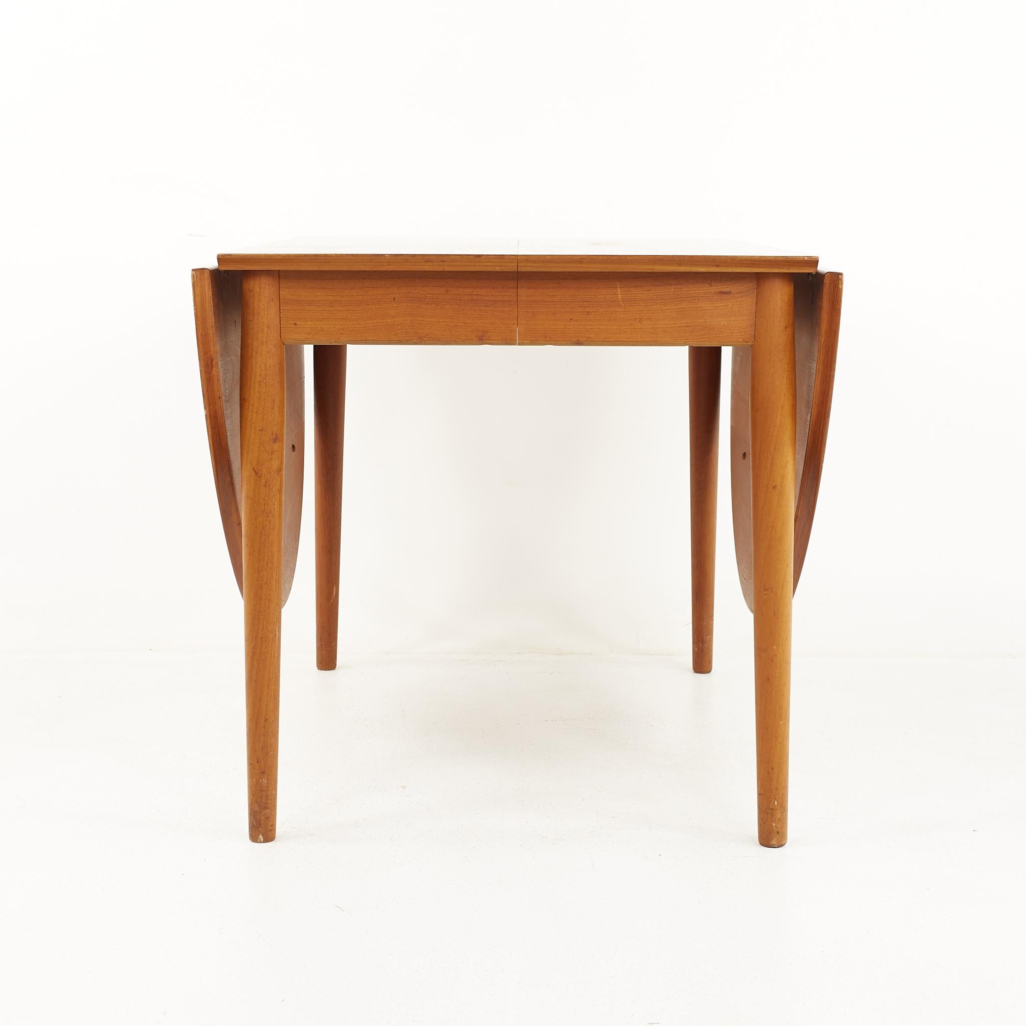 Arne Vodder for sibast mid century Danish teak drop leaf expanding dining table with 2 leaves

The table measures: 70 wide x 41.5 deep x 28.5 high, with a chair clearance of 24 inches; each leaf is 22 inches wide, making a maximum table width of