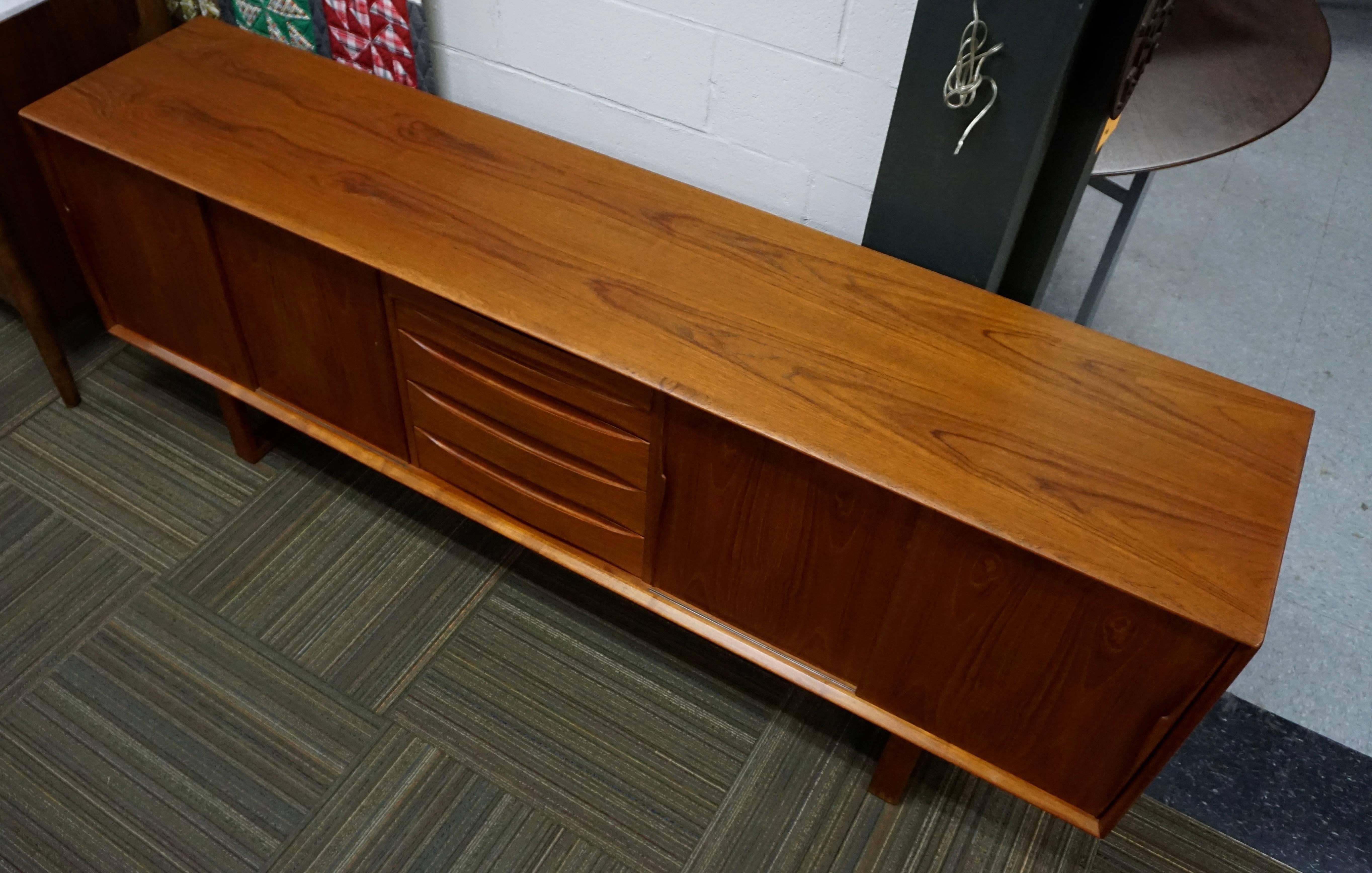 Teak , nicely restored with oil and wax. A few minor marks on top and bottom of legs. Two shelves behind each pair of doors. Nice grain pattern on veneer.