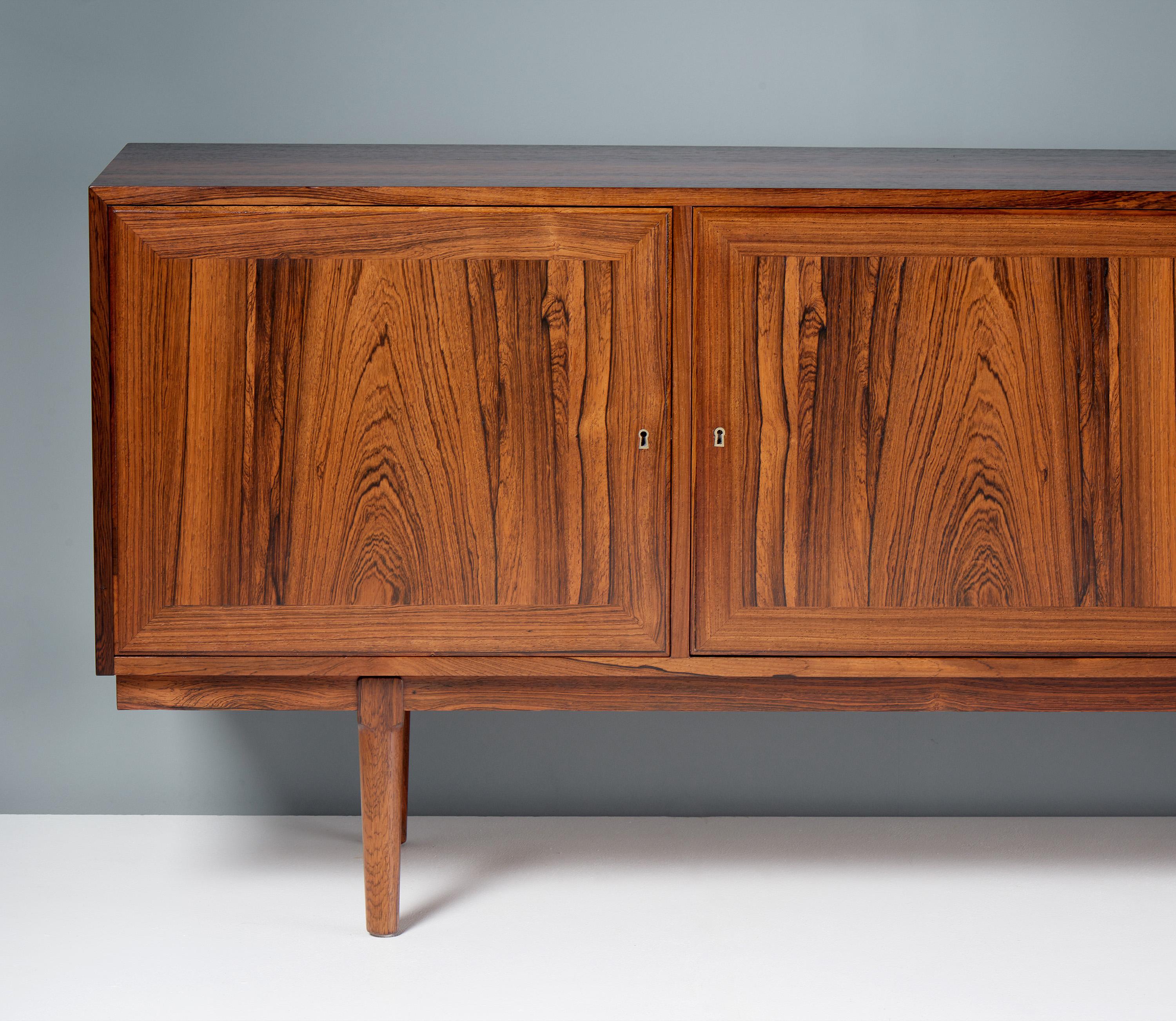 Rarely seen long credenza/sideboard with 4 lockable doors designed by Arne Vodder for Vamo Møbelfabrik, in Sønderborg, Denmark. This exceptional and rare sideboard was produced using the very finest rosewood stock. The frame and legs are solid