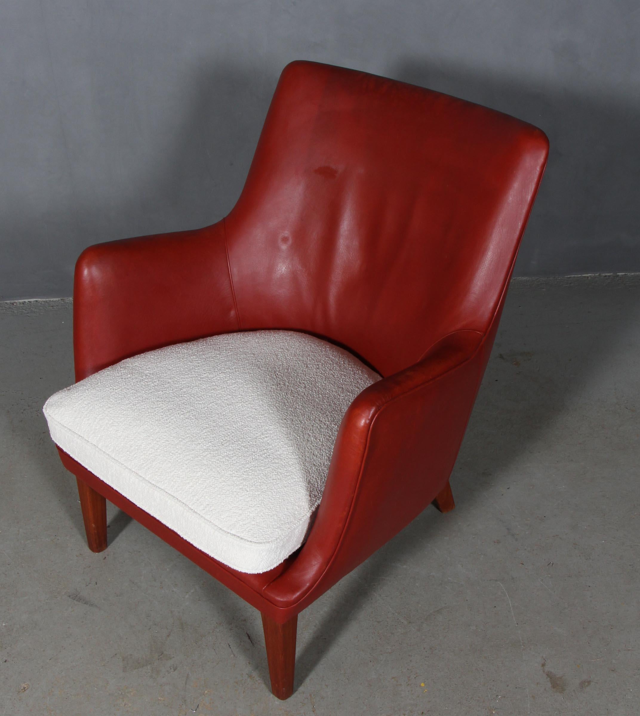 Arne Vodder lounge chair in original red patinated leather.

Cushion of white boucle.

Legs of teak. 

Made by Ivan Schlechter. With metal plate from cabinetmaker.