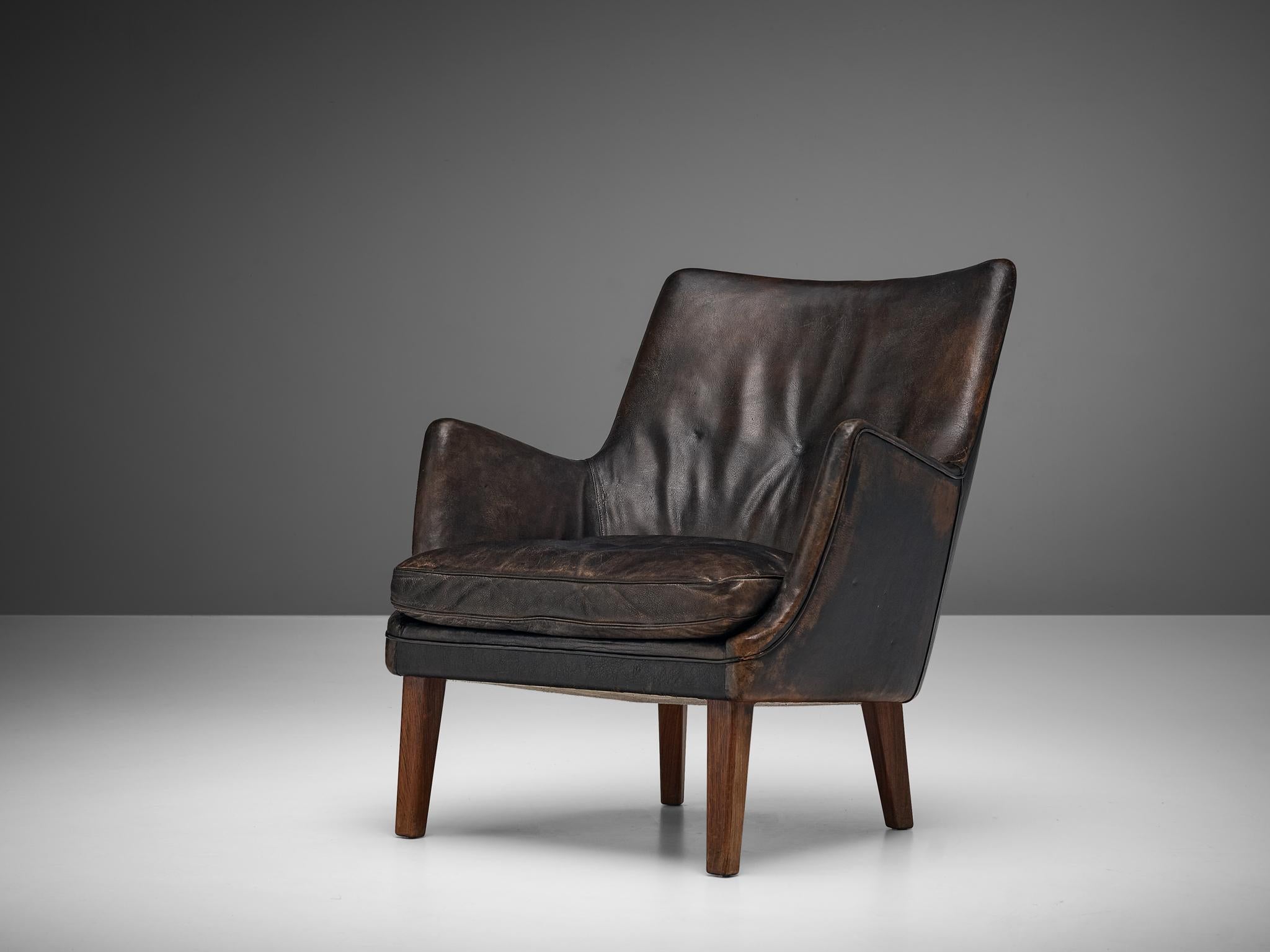 Arne Vodder for Ivan Schlechter, lounge chair, leather, wood, Denmark, 1953

Distinct design by Arne Vodder in 1953. The shape of the lounge chair is created by the high, slanted backrest with rounded armrests. A seating cushion provides comfort.