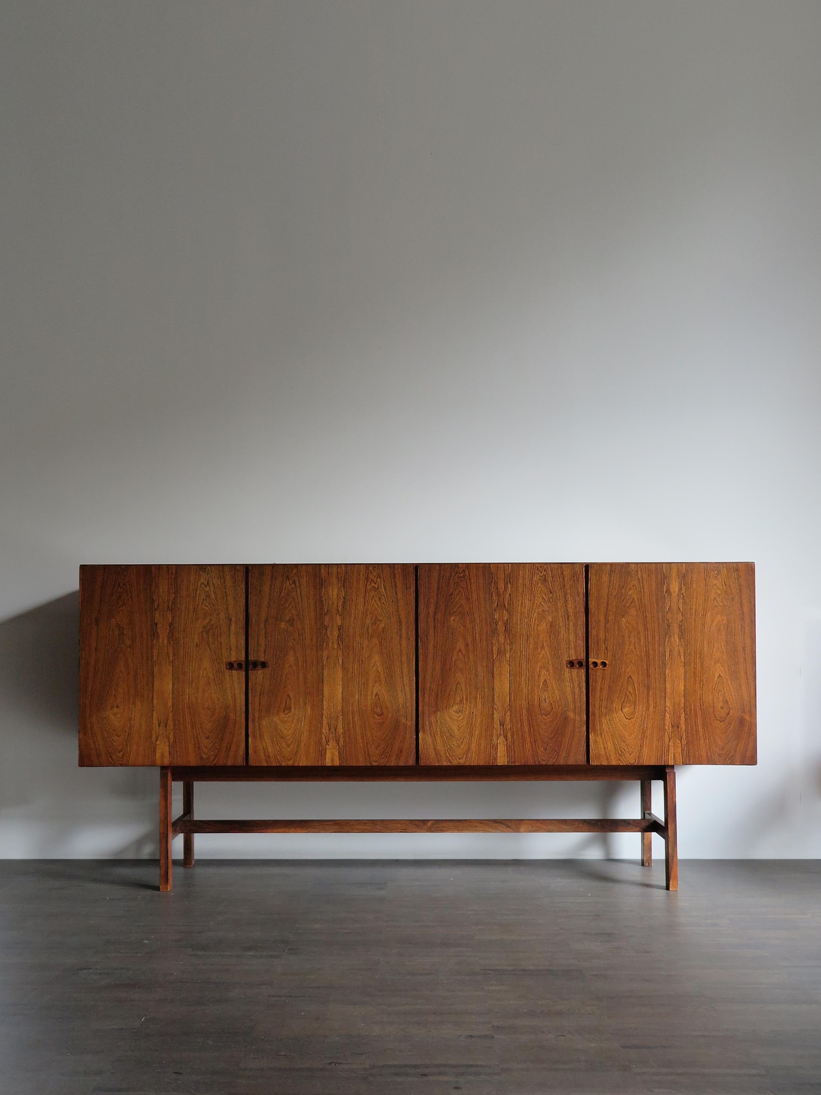Scandinavian elegant and amazing dark wood big or height sideboard designed by Danish important artist Arne Vodder with bar space inside, brass details, circa 1960s.

Please note that the sideboard is original of the period and thus shows normal