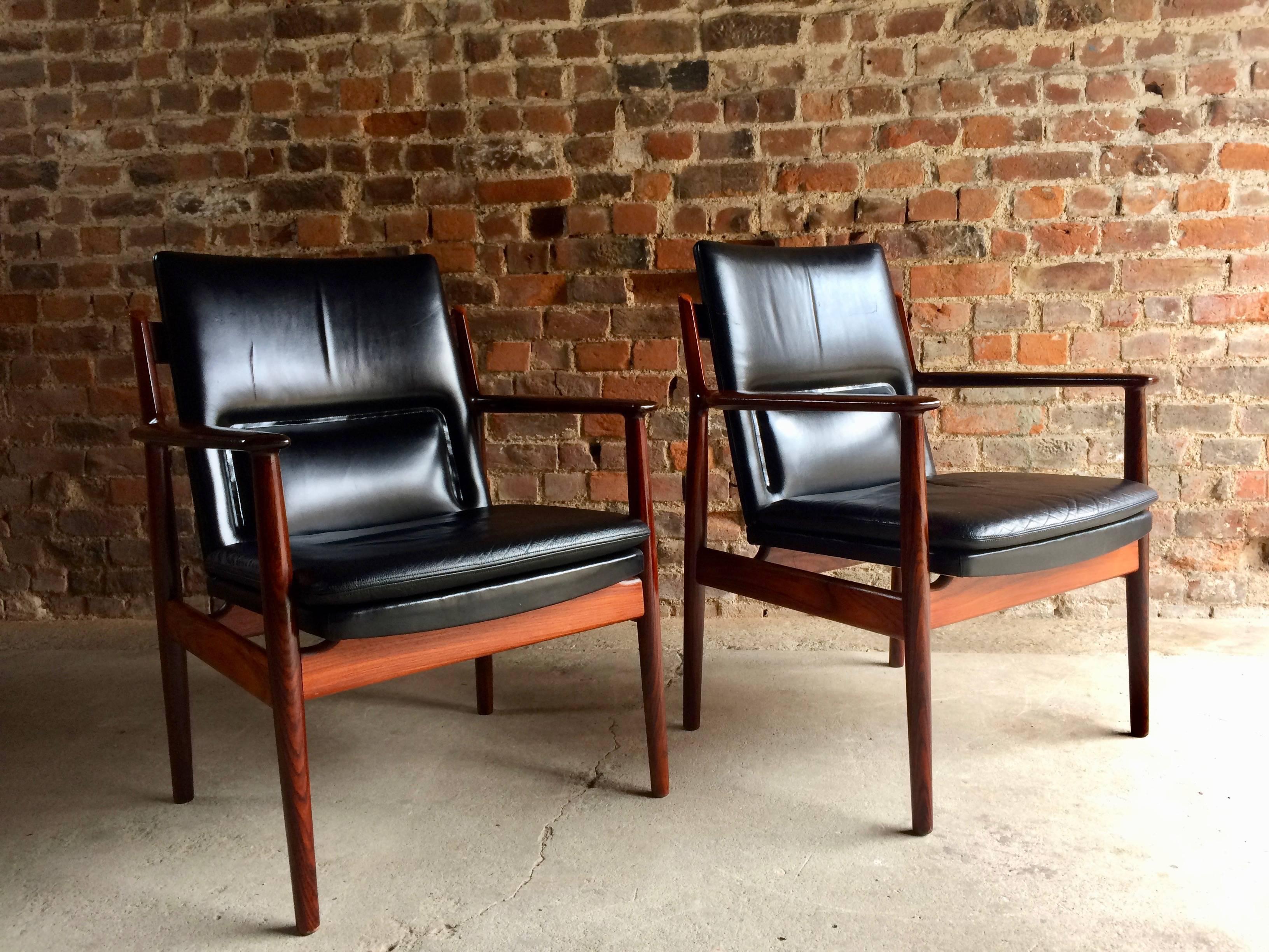 Magnificent pair of Arne Vodder model 431 black leather and solid rosewood armchairs manufactured by Sibast Furniture, circa 1965, with solid rosewood frames and black leather upholstery, makers label to underside of each chair.

Note: Sold in