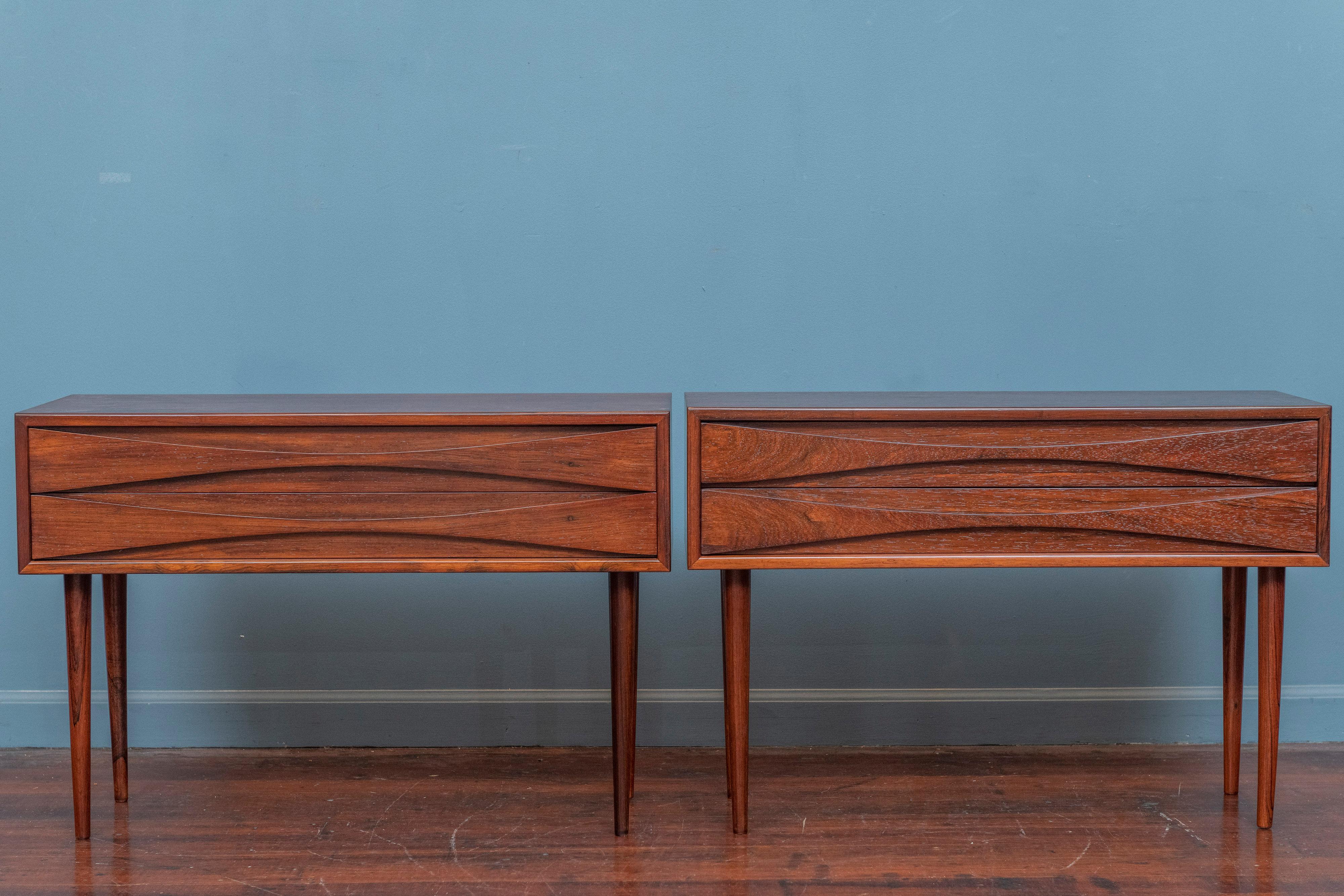 Niels Clausen design rosewood nightstands for N.C. Mobler, Denmark. Sophisticated design by a Danish design master executed in Brazilian rosewood with his signature drawer pull design. Rare pair of nightstands that have just been newly refinished
