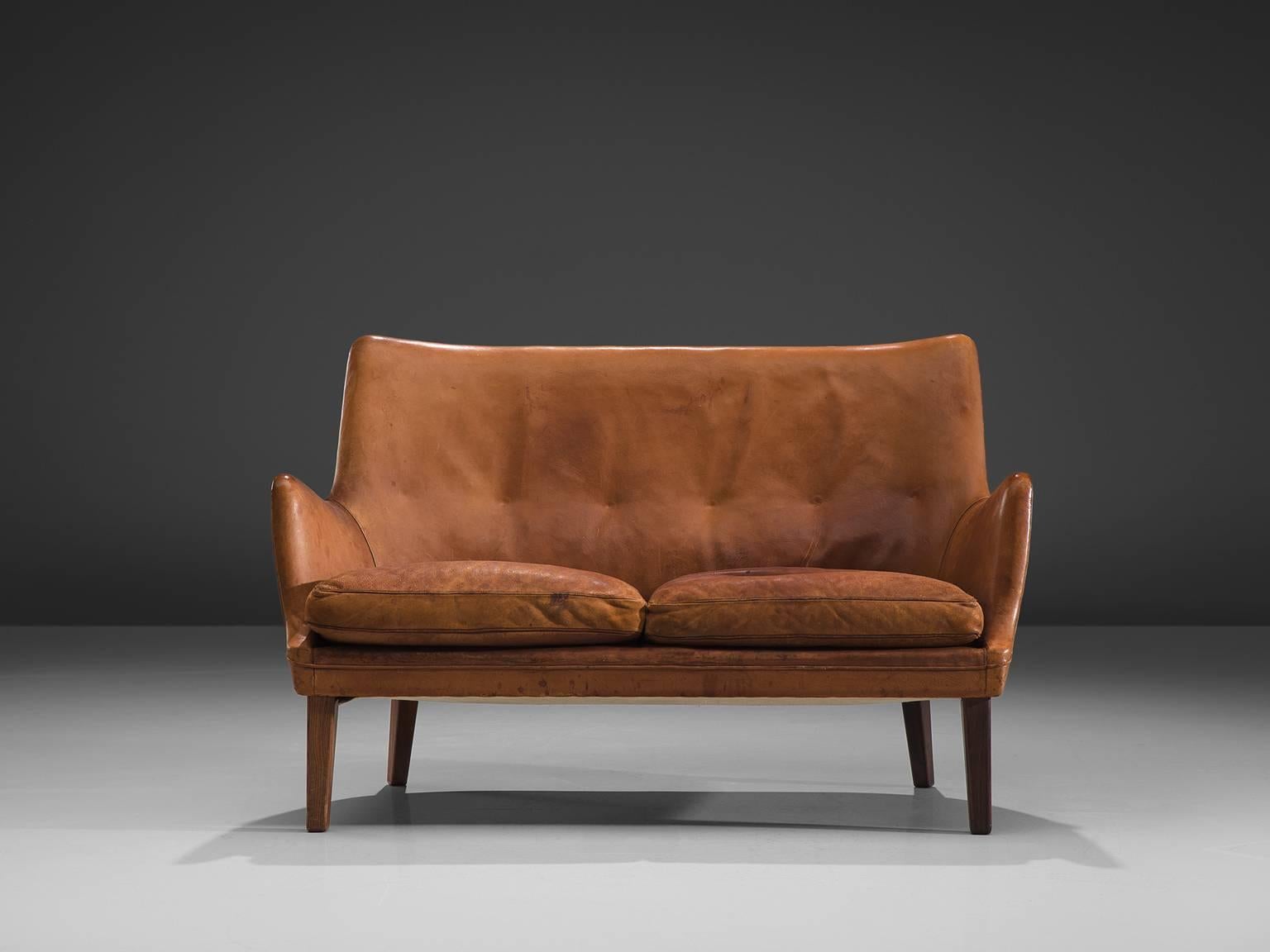 Arne Vodder for Ivan Schlechter, sofa, cognac leather and rosewood, Denmark, 1953.

Elegant two-seat settee in cognac leather and rosewood by Danish designer Arne Vodder and upholstered by master upholster Ivan Slechter. This sofa shows the great