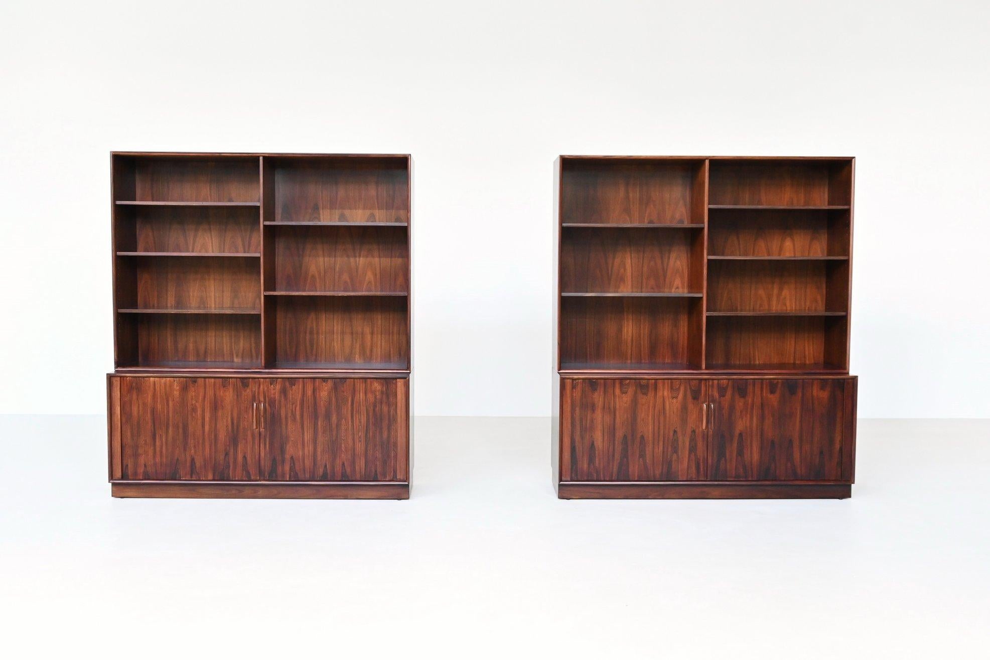 Splendida coppia di librerie disegnate da Arne Vodder e prodotte da Sibast Møbler, Danimarca, 1960. Questi eleganti armadi sono realizzati in legno di palissandro dalla ricca venatura e sono caratterizzati da porte scorrevoli a tamburo con maniglie