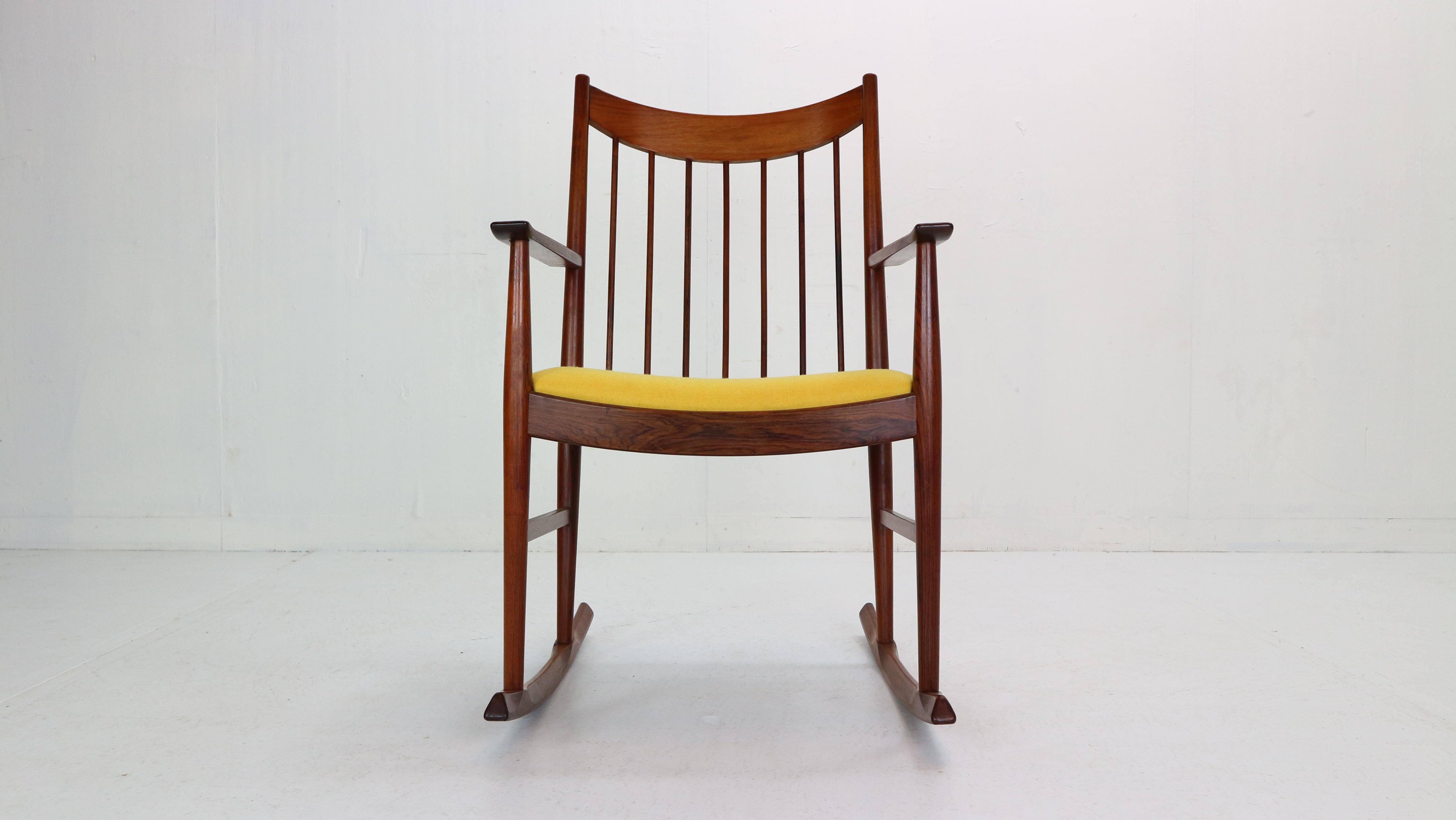 Scandinavian Modern period rocking chair designed by Arne Vodder for Danish furniture manufacture Sibast in 1960s period.

The chair is composed from solid rosewood with curved spindle back rest.
The cushion of the seating has been newly