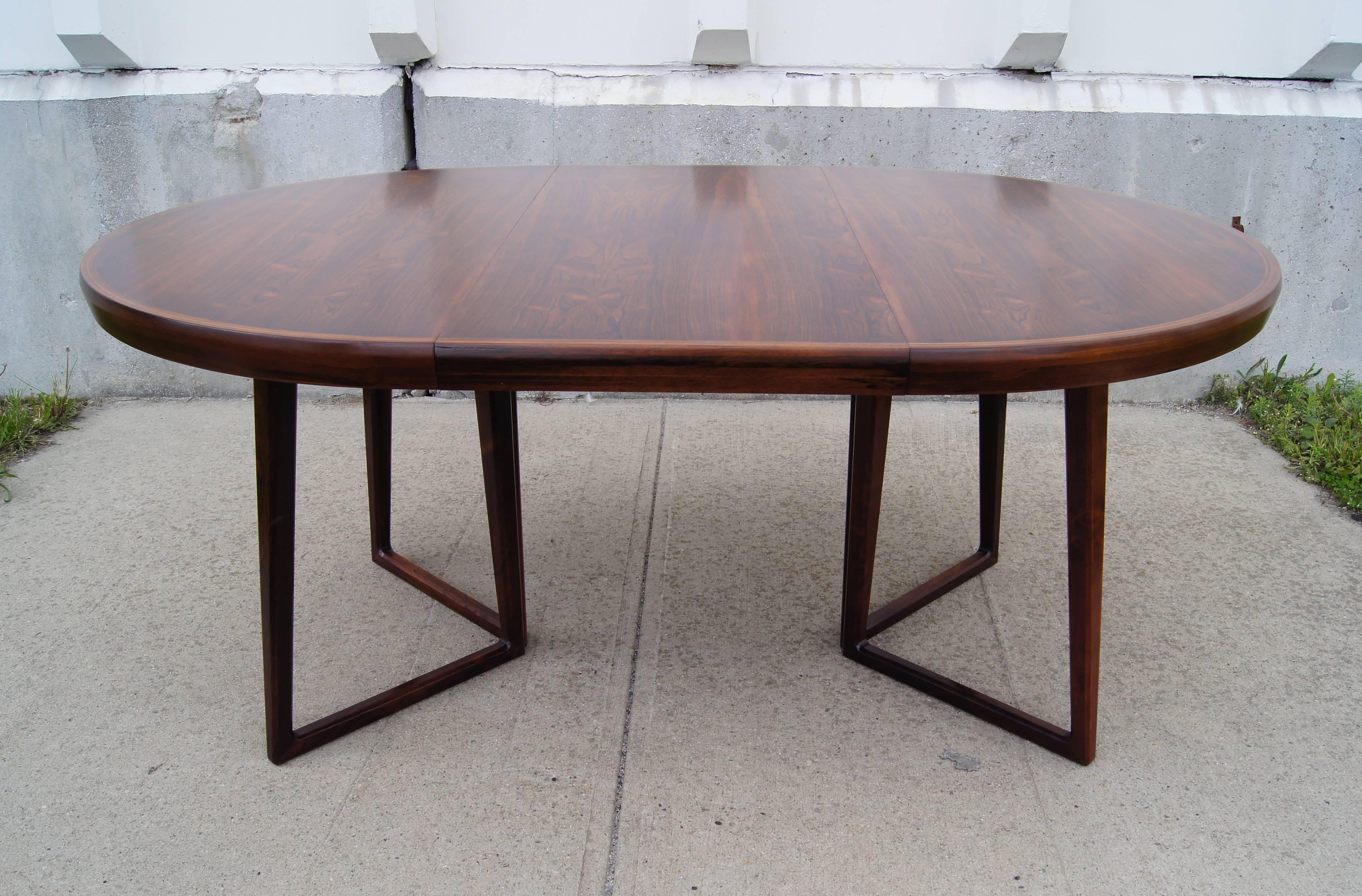 This dining by Arne Vodder comprises a beautiful rosewood table. The table has a unique angled base and comes with a 19.5 in. leaf that expands the round top into an oval.
    