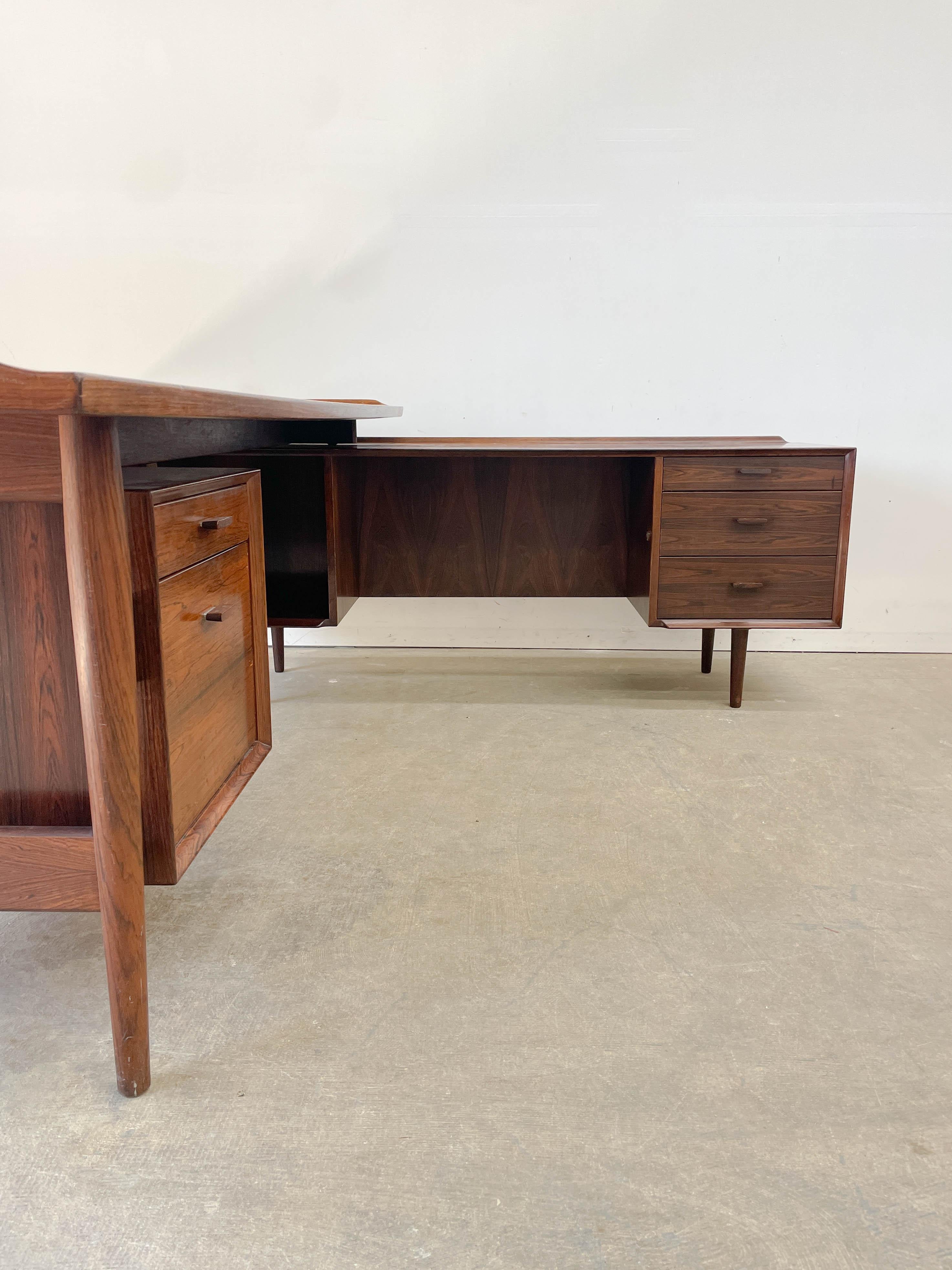 Exquisite Rosewood desk and return designed by Arne Vodder for Sibast Furniture in the 1950s. Featuring a very generous desktop, drawer with original leather stationary tray and hanging file drawer below and on the return a cubby with adjustable