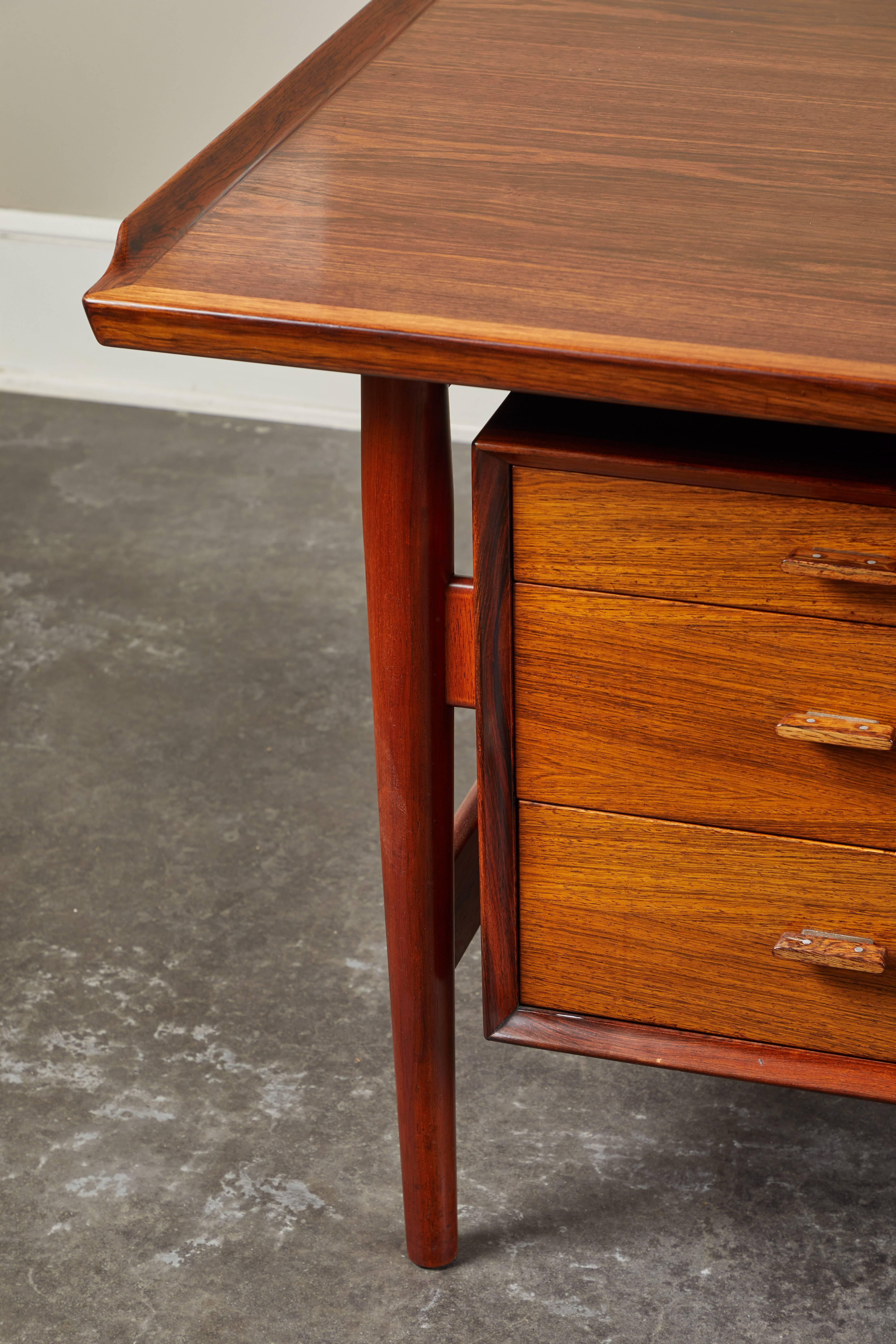 Danish Mid-Century Modern rosewood desk designed by Arne Vodder. Bold, executive style from every angle. Three drawers on the left, two on the right - the lower drawer is a file drawer.