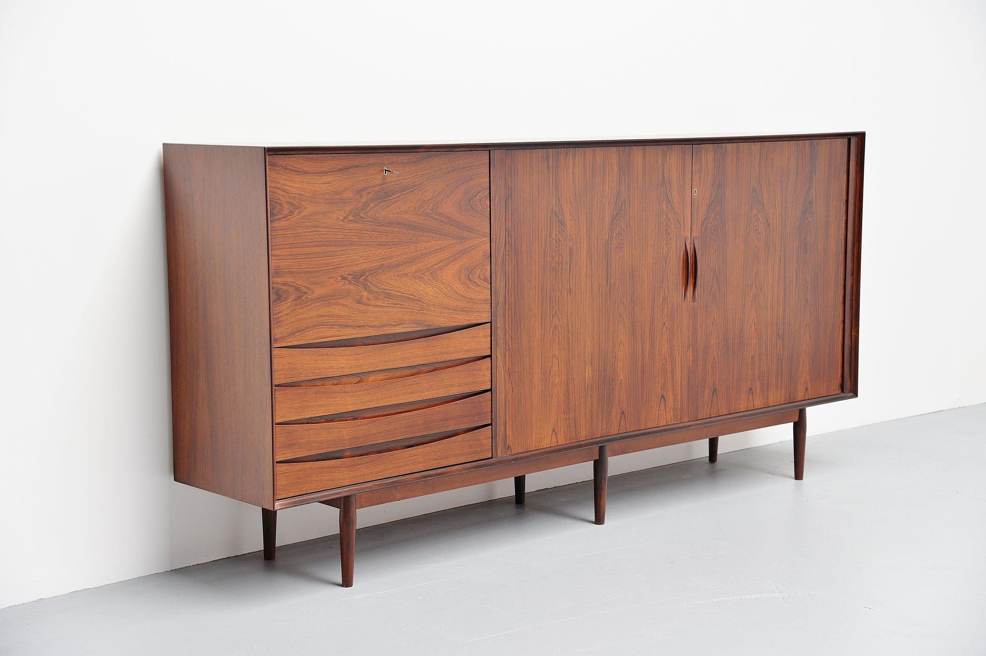Superb quality rosewood highboard designed by Arne Vodder, manufactured by Sibast Mobler, Denmark 1960. This highboard has amazing storage oppertunities. It has 2 large tambour doors on the right with several (adjustable) shelves behind and 3