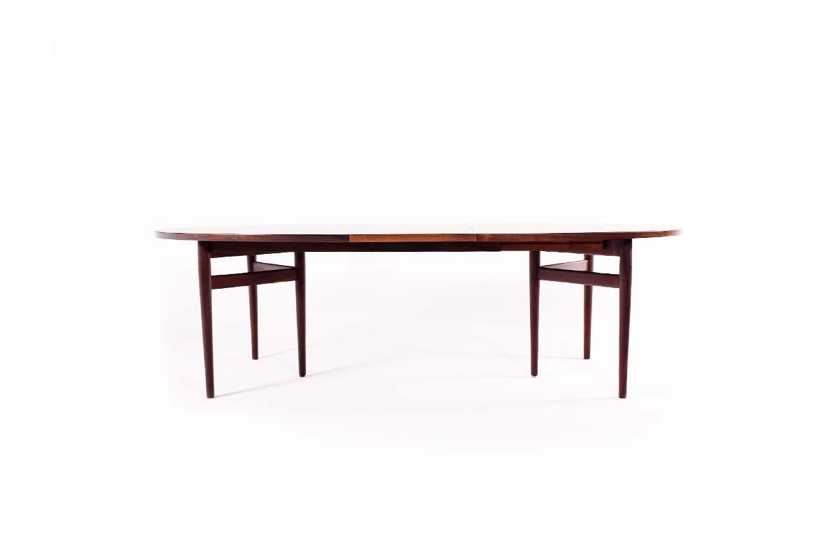 This oval table, model 212, was designed by Arne Vodder and manufactured by Sibast in Denmark, 1950s. Made of rosewood with simple legs that open when the extension is attached. Table with a good dimension when closed. One leaf with 50 cm.