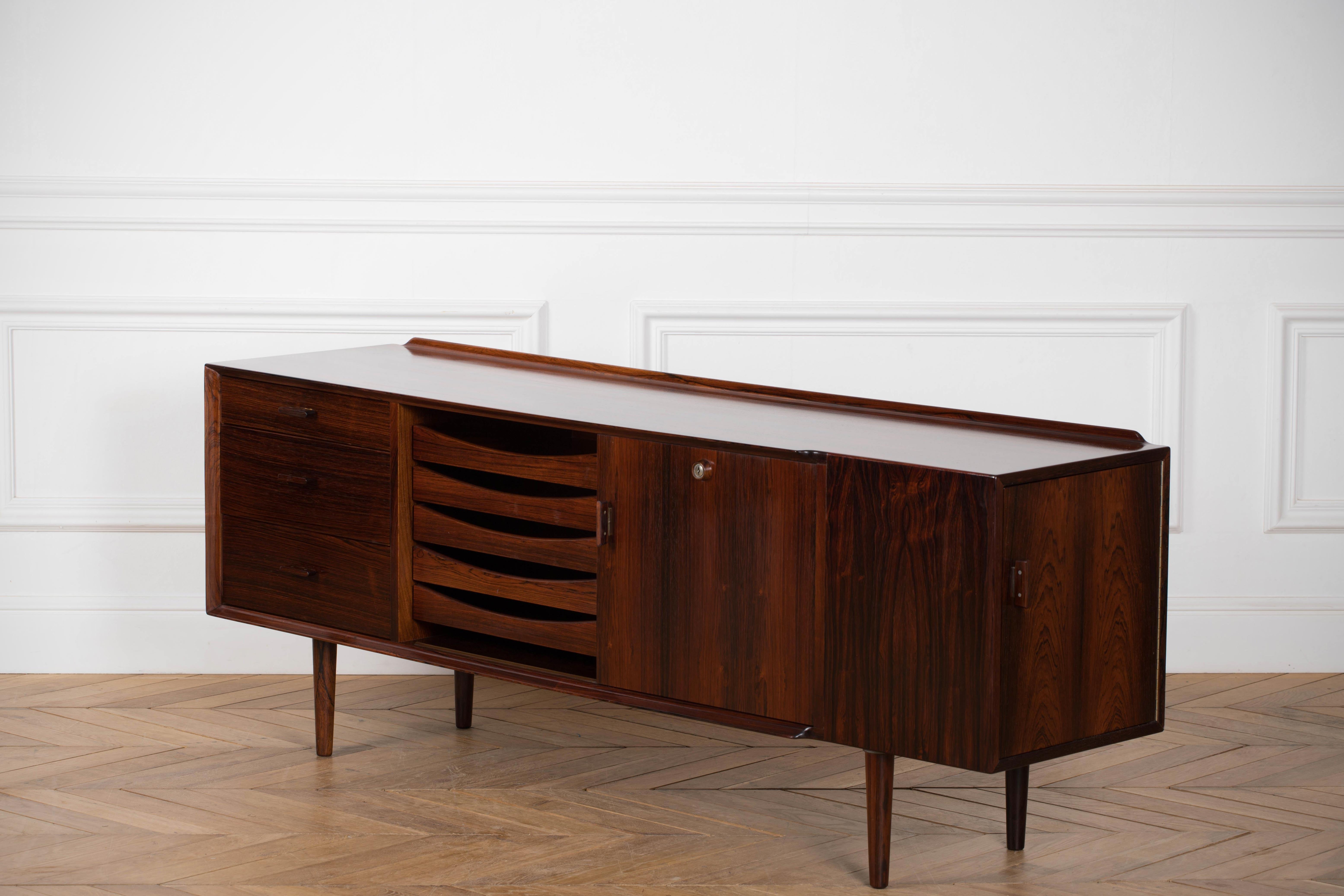 Particularly beautiful sideboard, designed by Danish designer Arne Vodder for Sibast, Denmark in the 60's. The sideboard is made of tropical hardwood and has a very nice pattern in the woodgrain. The sideboard has a sliding doors hidding either one