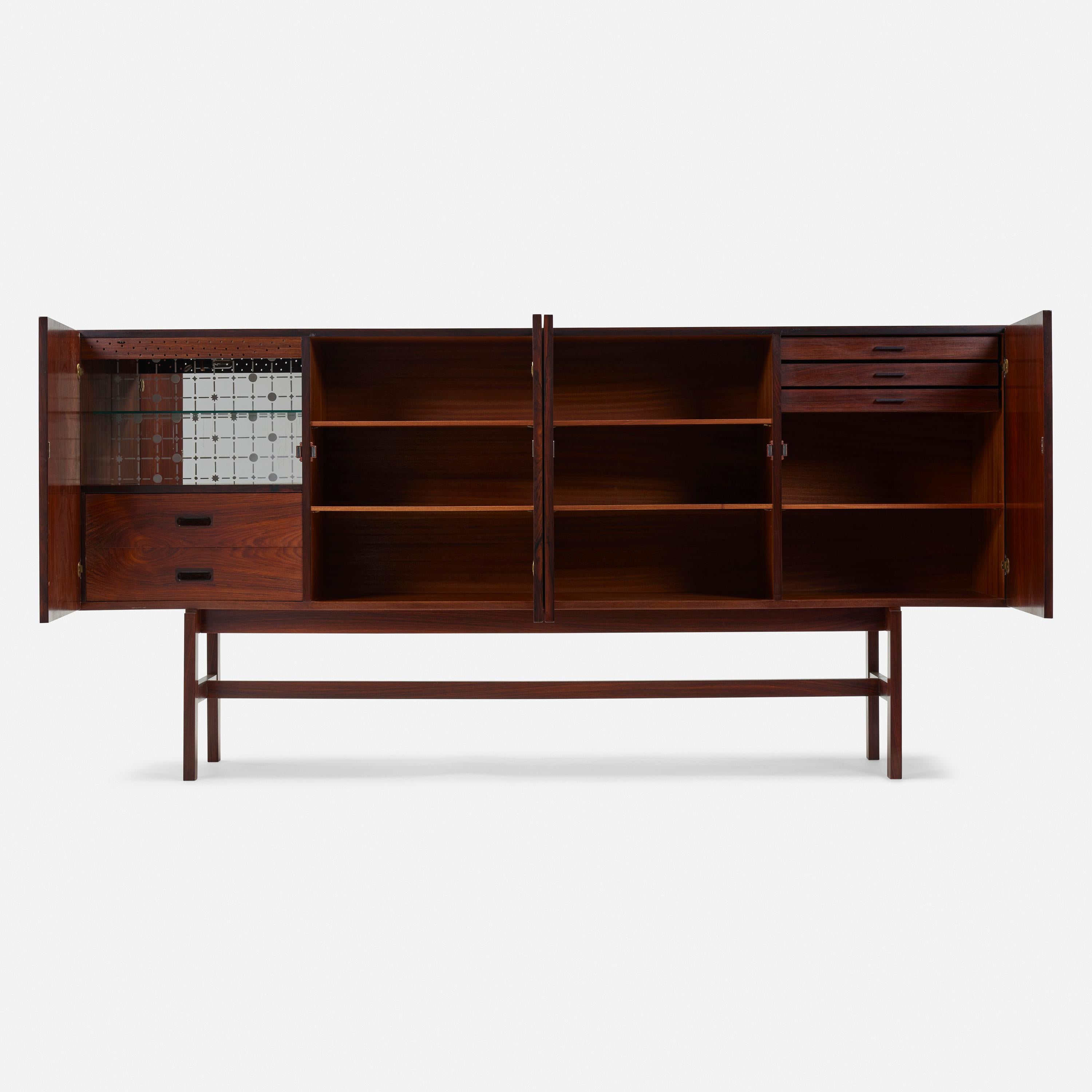 Rosewood Sideboard designed by Arne Vodder c 1965. Manufactured by Sibast Møbler.

The stature and ‘lift” to this piece at 42” high, distinguishes itself from the more typical 34” high pieces. The Rosewood grain is beautifully matched in a vertical