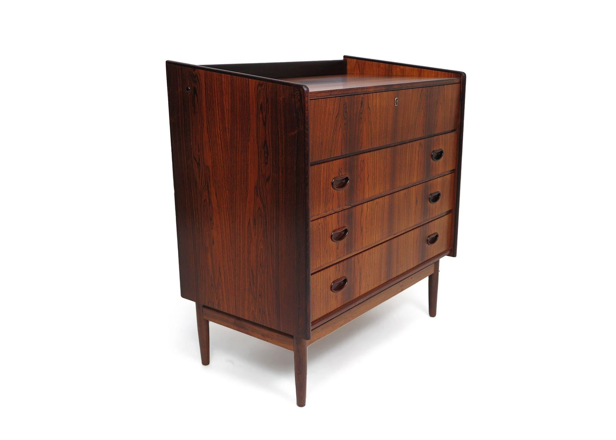 circa 1955 Brazilian rosewood vanity with flip-top mirror and lights. Crafted of stunning Brazilian Rosewood with dark grains and dynamic book-matched patterns across the front of drawers and sides. The secretary features a locking flip-top vanity