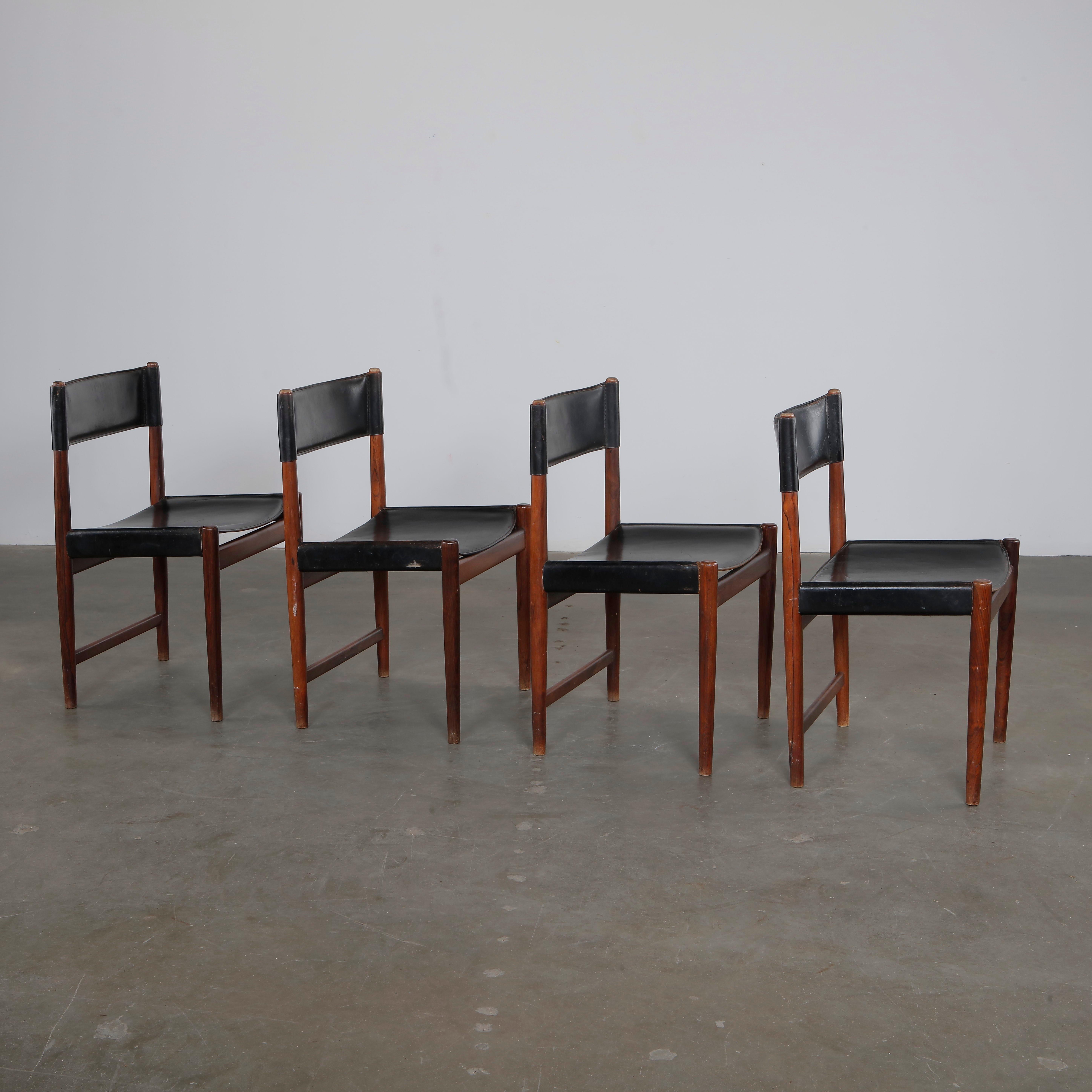 Un lujoso juego de cuatro sillas de comedor del maestro danés Arne Vodder para Sibast. Estas sillas de los años sesenta están fabricadas en palisandro ricamente veteado con asientos de flexible cuero negro. Los respaldos elegantemente curvados