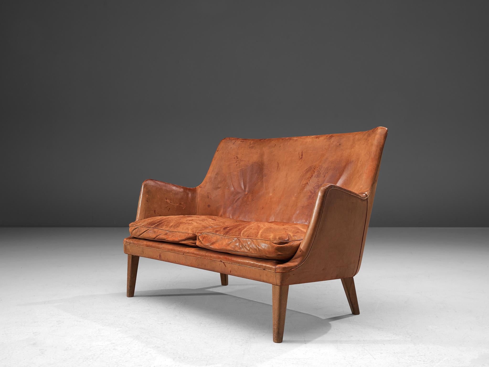 Arne Vodder for Ivan Schlechter, settee sofa, patinated leather and teak, Denmark, design 1953, manufactured late 1950s-1960s.

Elegant two-seat settee in admirable cognac leather and teak by Danish designer Arne Vodder and upholstered by master