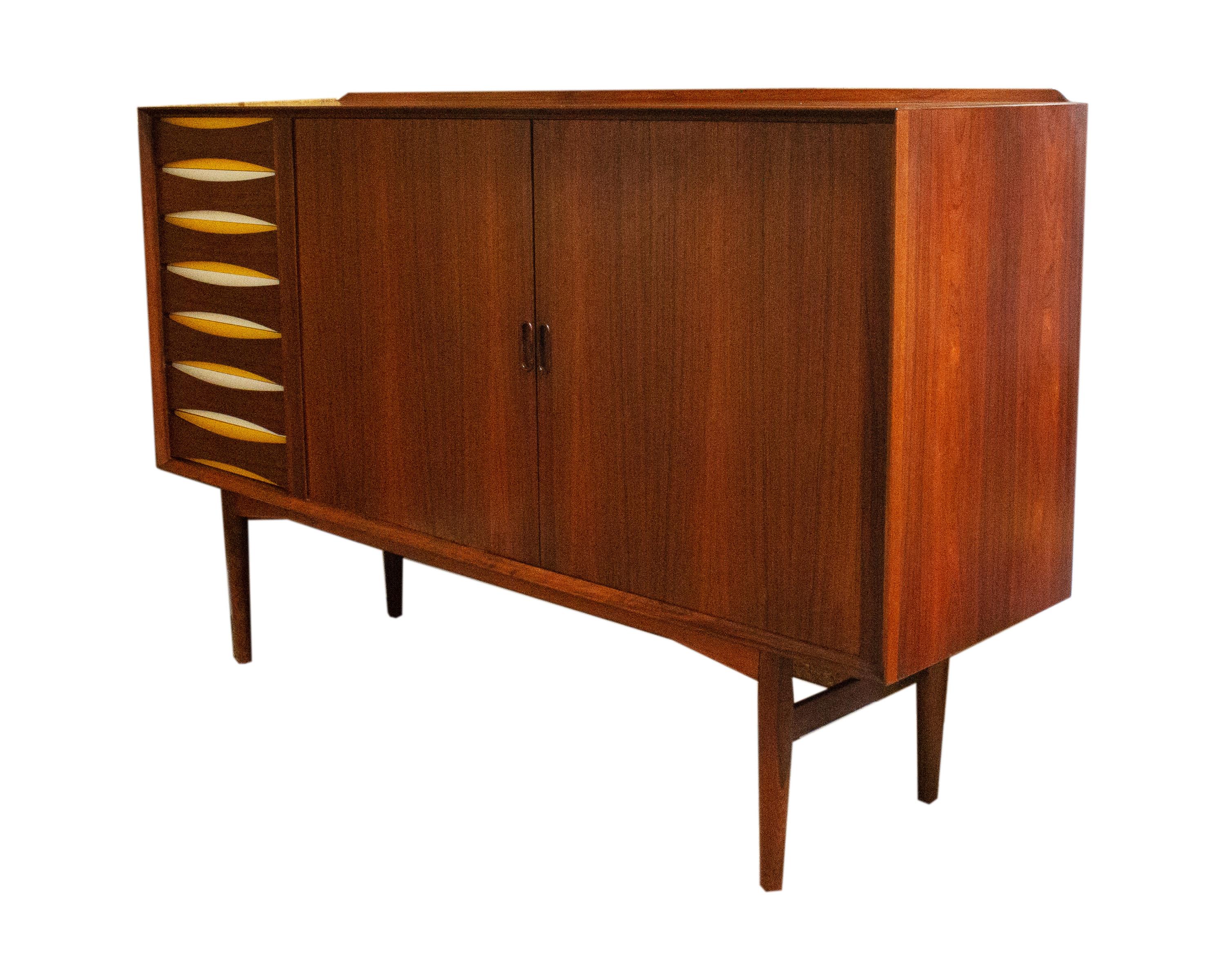 A rosewood cabinet designed by the Danish designer Arne Vodder (1926-2009) for Sibast Møbler. Made in Denmark, this tall cabinet features tamboured doors on the right and seven drawers on the left. Each drawer has a bowtie-shaped wooden front framed
