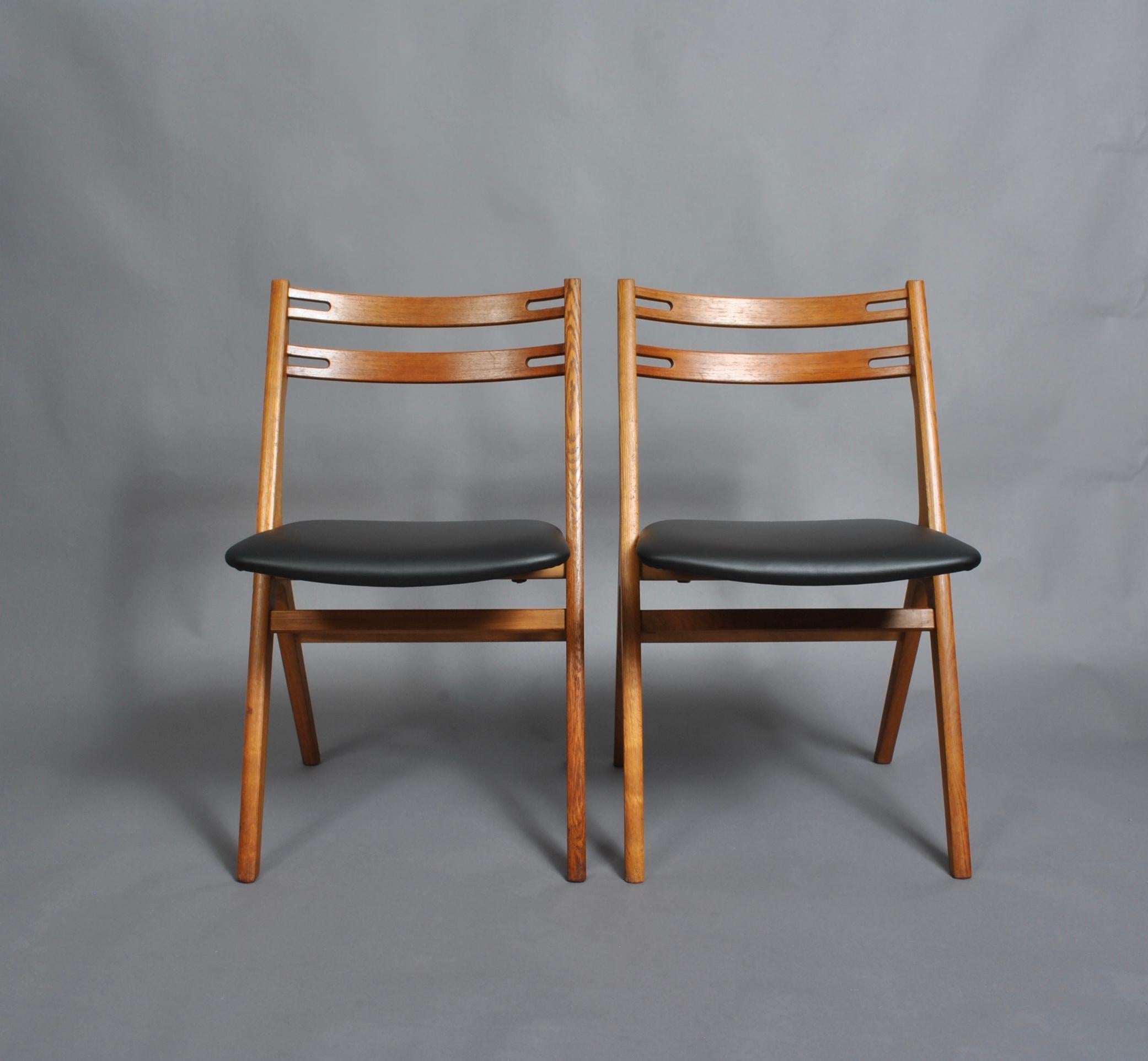 A set of six Danish oak saw back design dining chairs designed by Arne Vodder for Sibast, Denmark, circa 1960. Re-oiled frames with new reupholstered black leather seats. Original Sibast labels still intact underneath. Fabulous midcentury walking