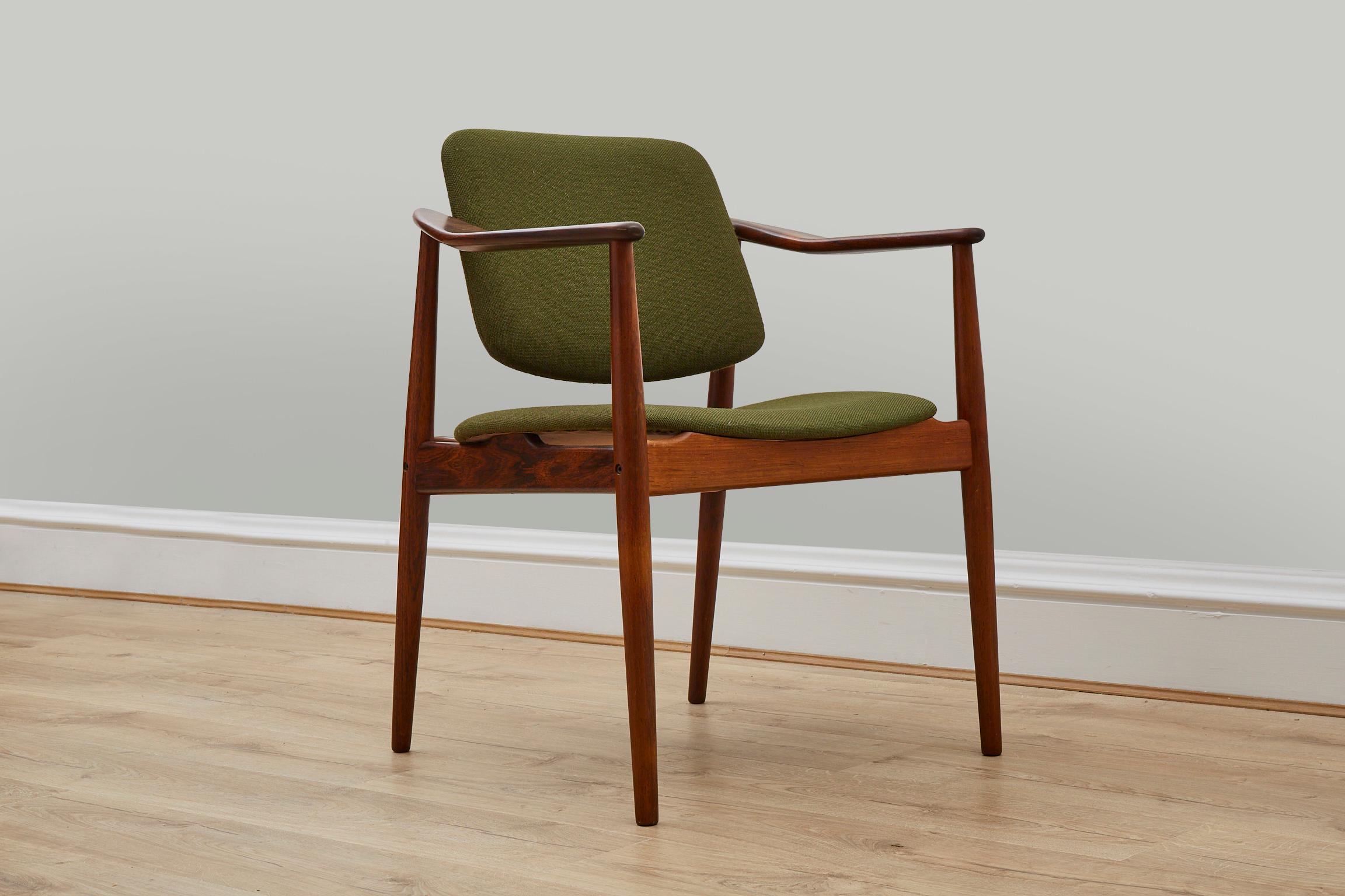 Danish modern rosewood arm chair, designed by Arne Vodder. This elegant chair has a seat, a back that pivots for comfort, and a solid rosewood sculptural frame. It could be used as a desk, dining, or side chair.
