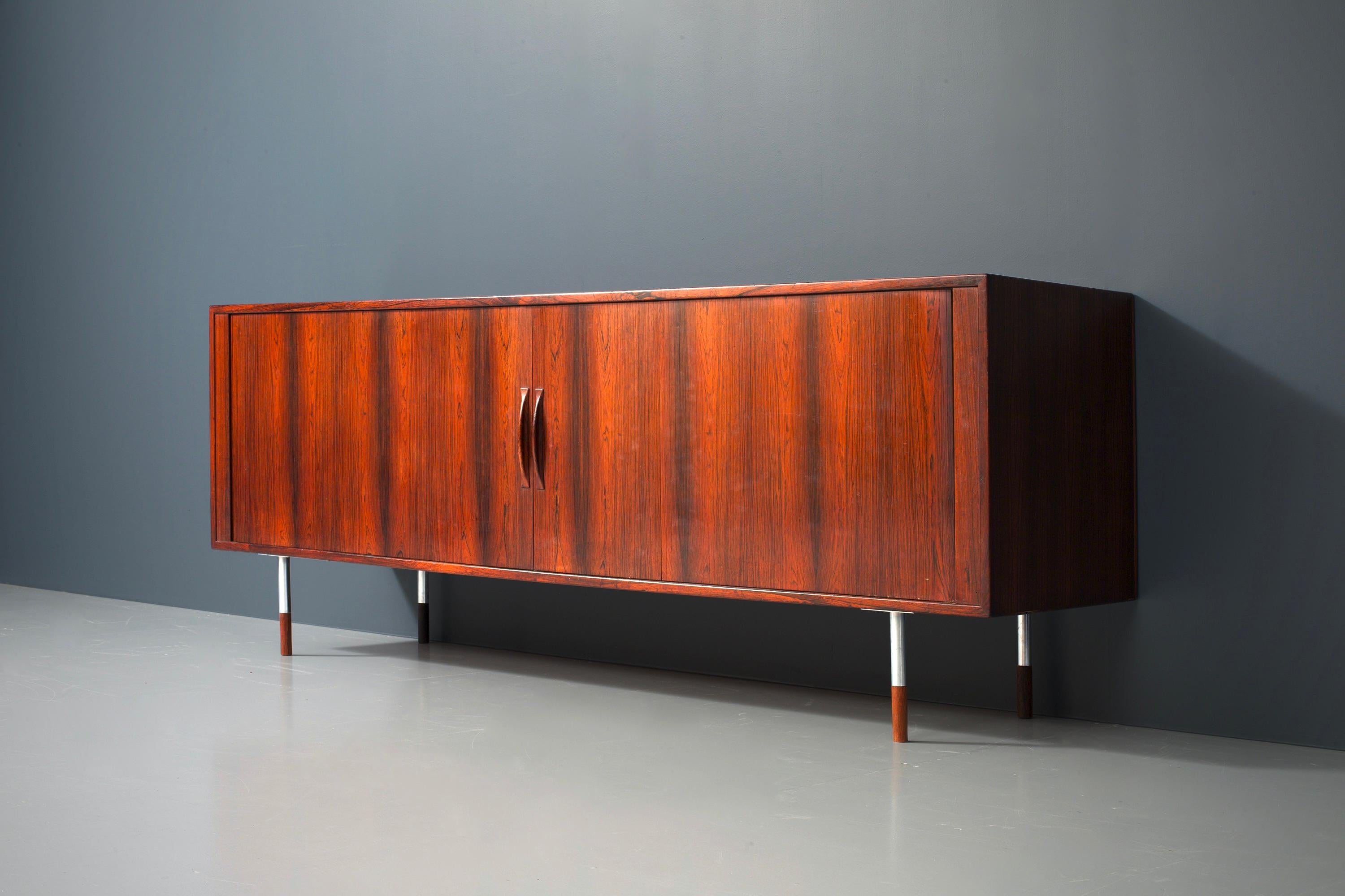 Sideboard with tambours doors by Arne Vodder for Sibast Møbler, recognizable by its simplicity. The design is modern and minimal yet very distinct. The latter is partly due to the round feet consisting of half wood and half metal. The rosewood has