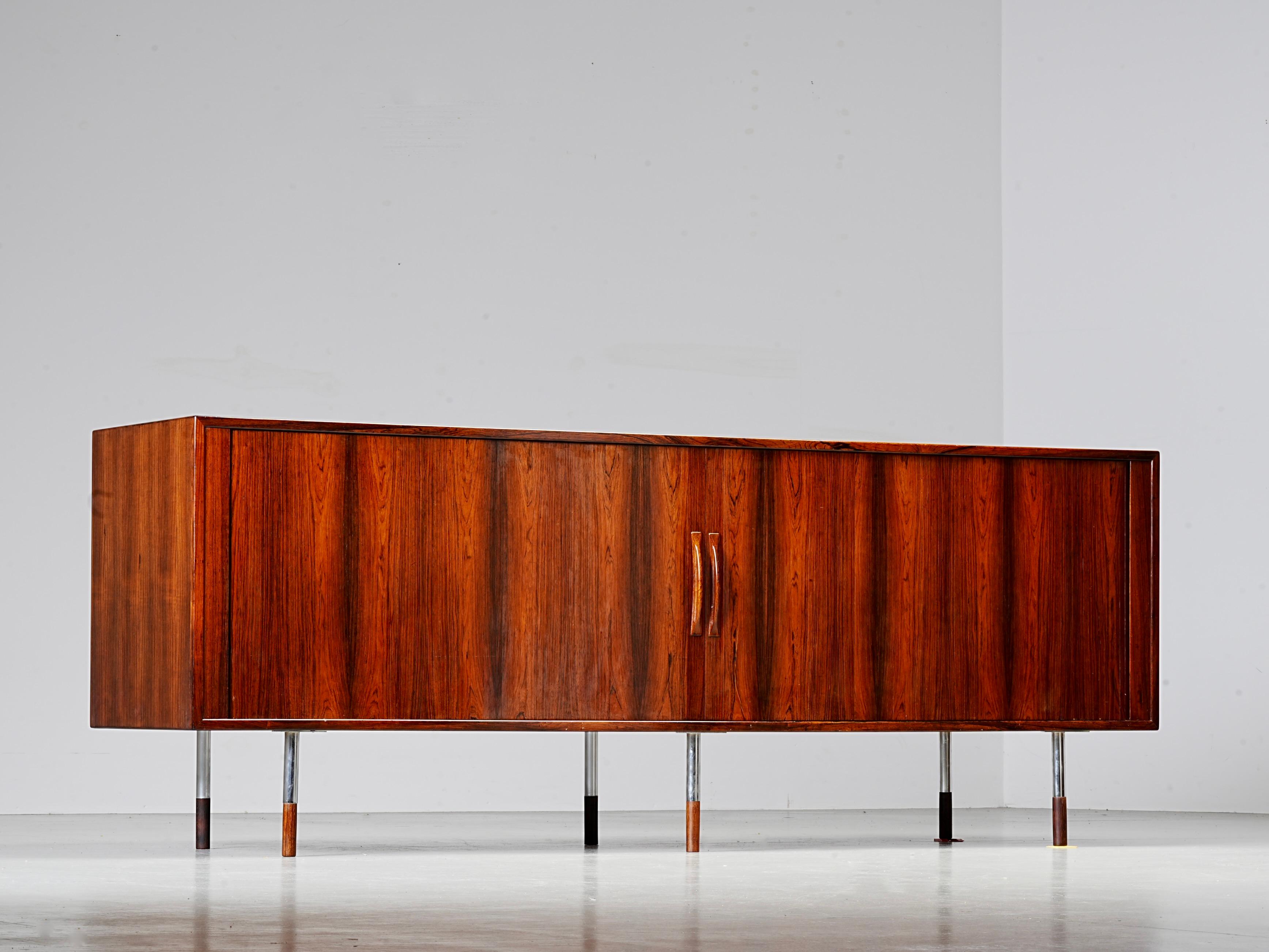 Arne Vodder Sideboard in Brazilian Rosewood and Metal, Denmark, 1960's

Sideboard designed by Arne Vodder, made in Denmark in the 1960's, with signature tambour doors that slide smoothly into the back panel. This clever construction makes for a