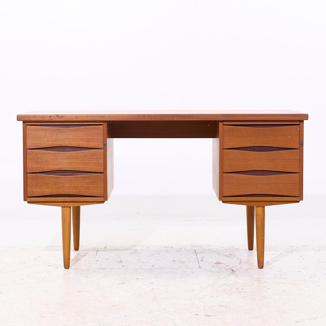 Arne Vodder Style Mid Century Danish Teak Desk

This desk measures: 52.25 wide x 24.25 deep x 28.25 high, with a chair clearance of 27 inches

We take our photos in a controlled lighting studio to show as much detail as possible. We do not Photoshop