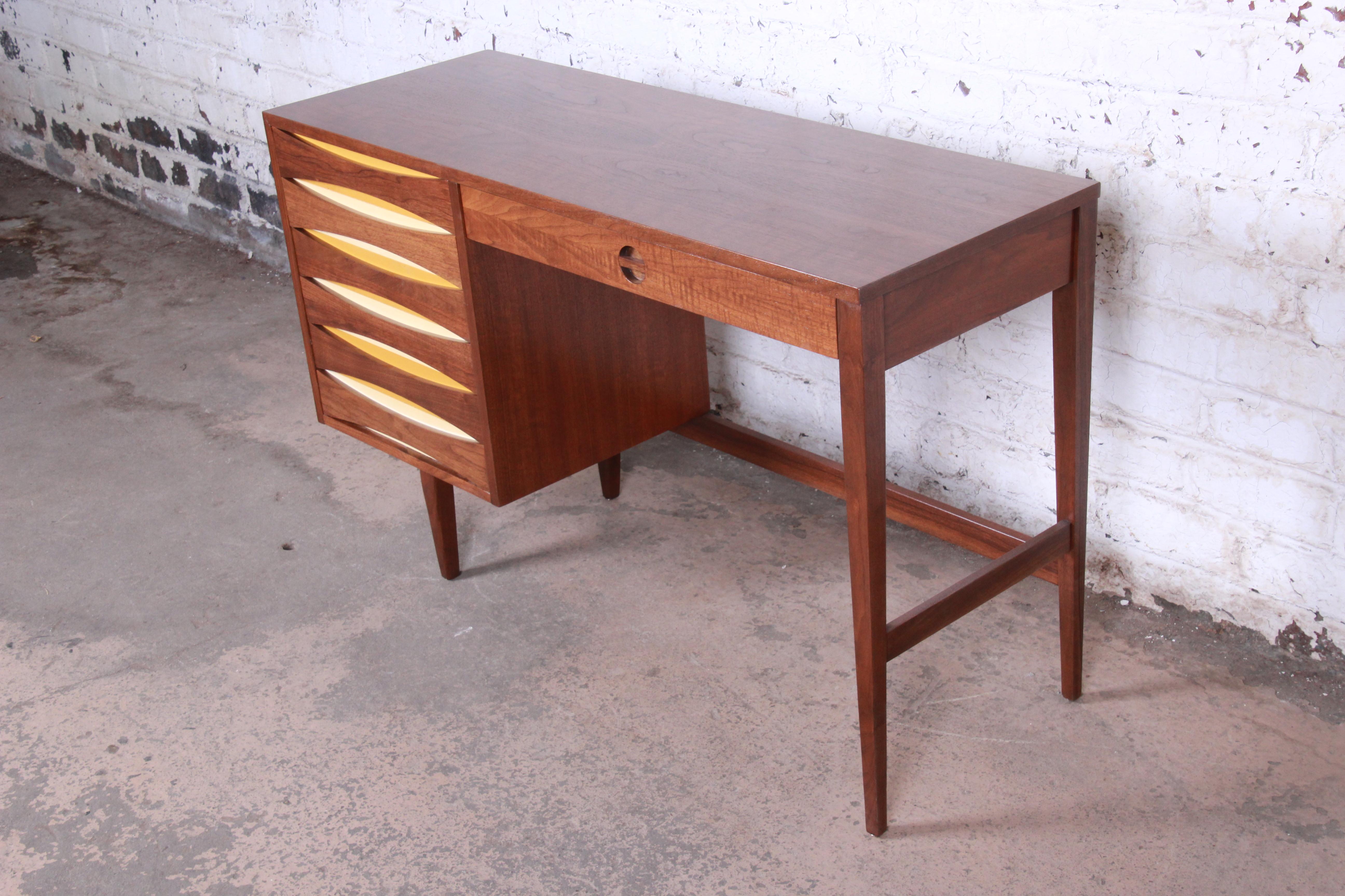 Mid-Century Modern Arne Vodder style walnut writing desk with unique drop-down file drawer

Made by West Michigan Furniture Co.

USA, 1960s

Walnut + lacquer in ivory and marigold

Measures: 48