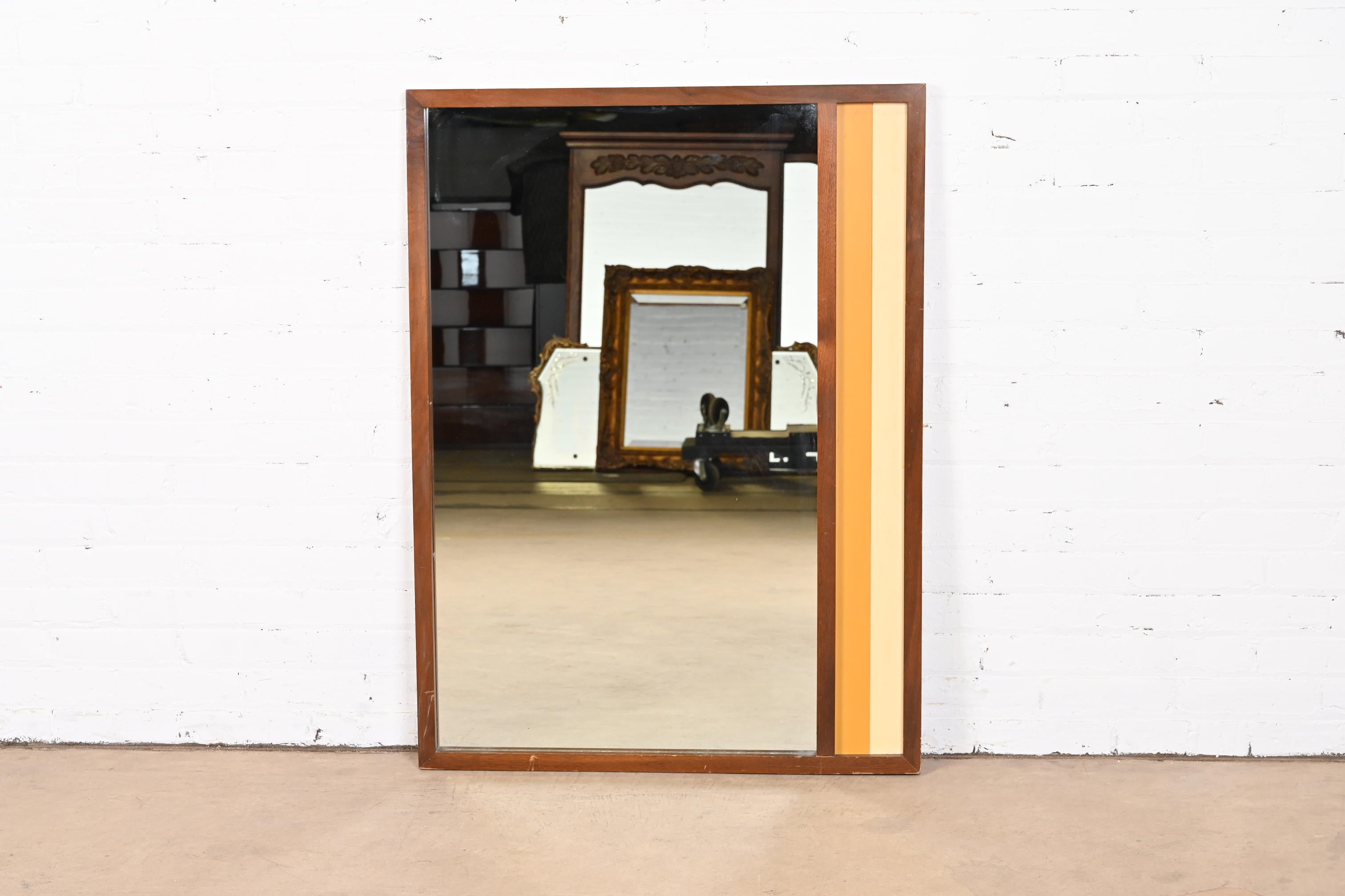 A gorgeous Mid-Century Modern walnut framed wall mirror

In the manner of Arne Vodder

USA, 1960s

Measures: 30.75