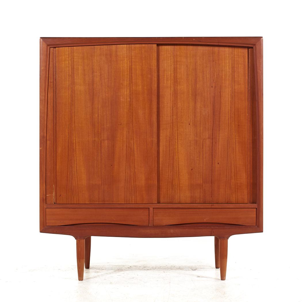 Arne Vodder Style Mid Century Teak Sliding Door Armoire

This armoire measures: 47.25 wide x 18.5 deep x 51.5 inches high

All pieces of furniture can be had in what we call restored vintage condition. That means the piece is restored upon purchase
