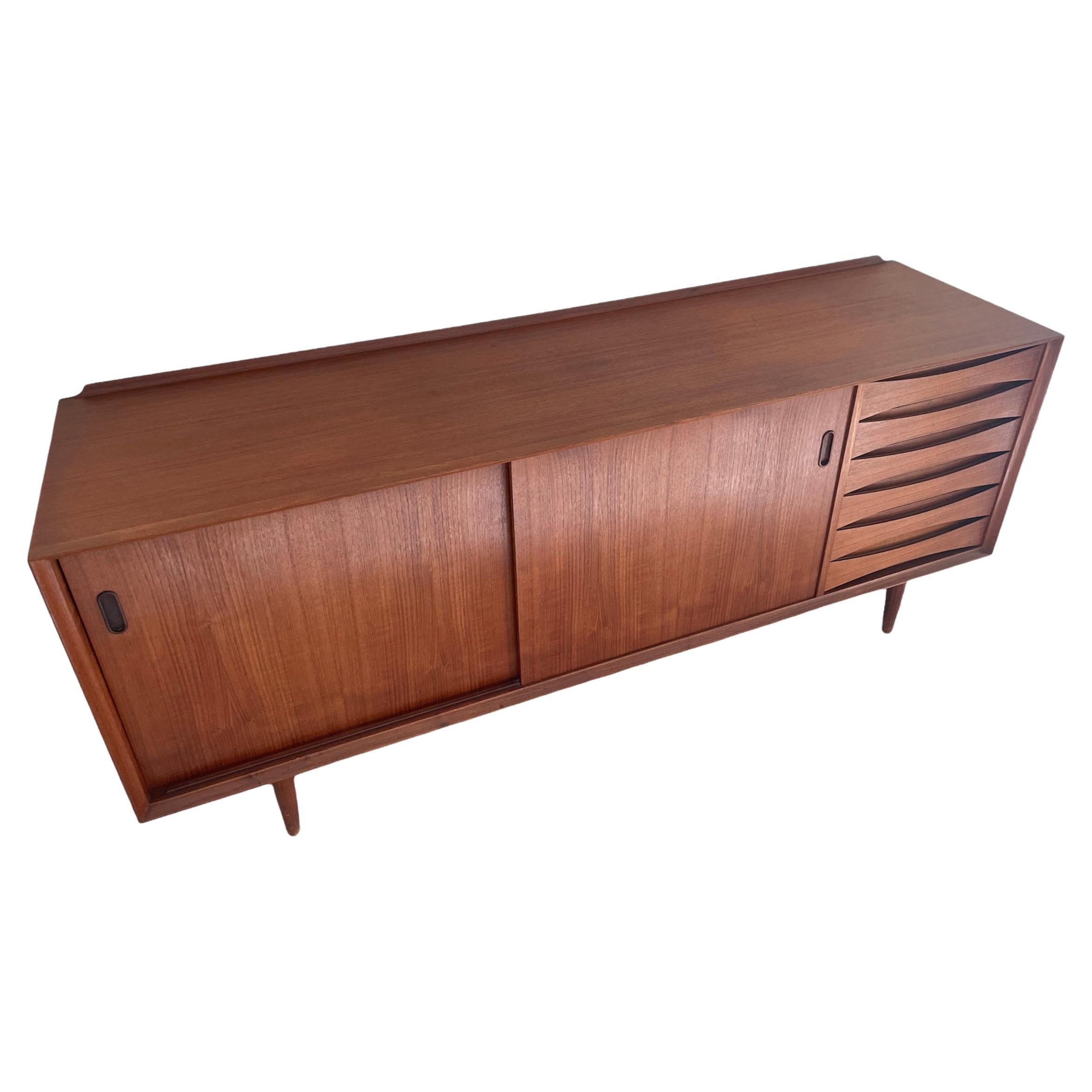 Stunning in every way!!!! 
This is the iconic credenza Model 21 designed by Arne Vodder for Sibast. 

The Model 21 sideboard has 6 drawers and 2 adjustable shelves behind 2 sliding doors. The beautiful bowtie front drawers are an amazing addition to