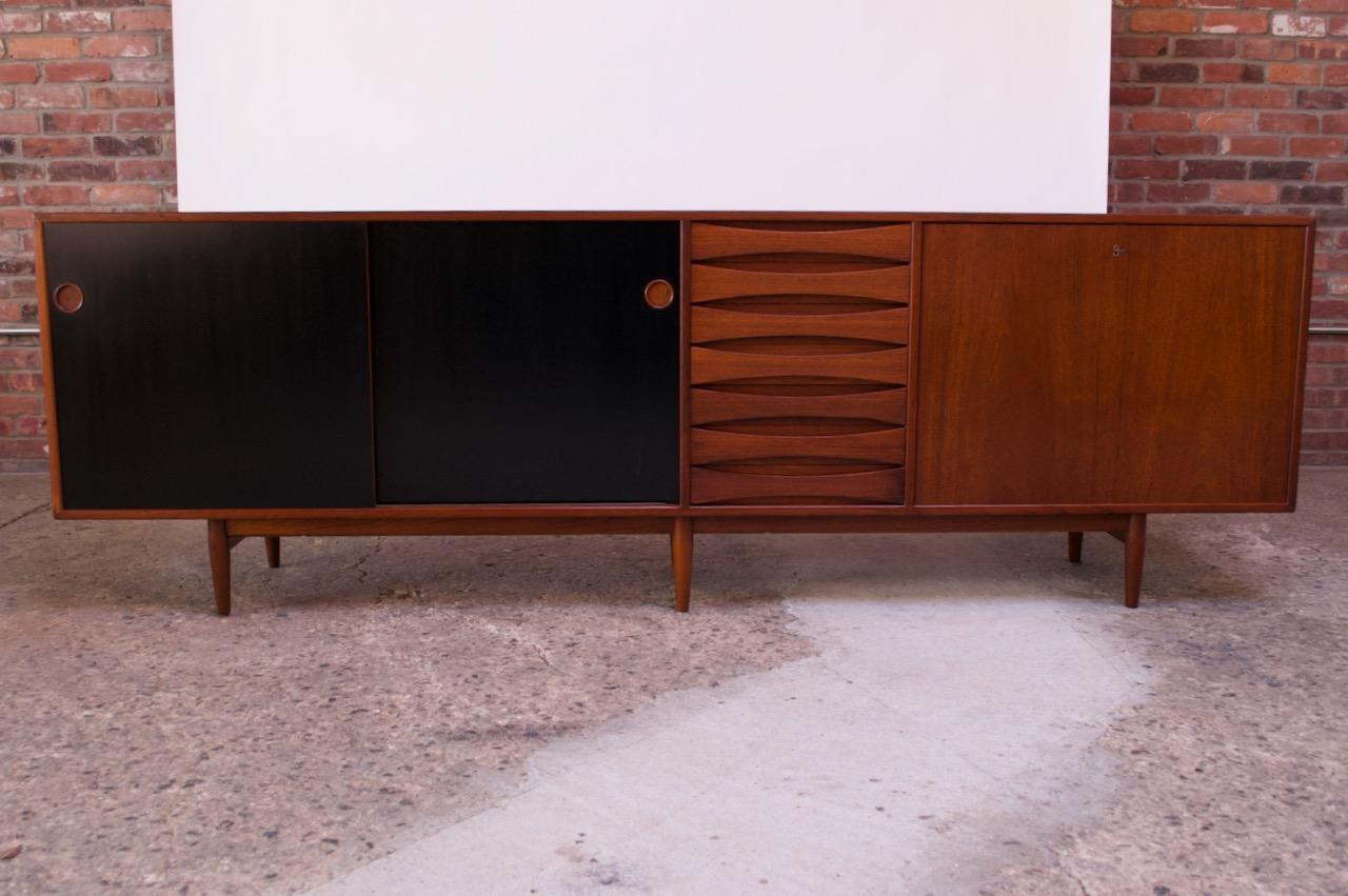 This impressive teak sideboard was designed in the 1950s by Arne Vodder for Sibast Mobler (Model 29A). It features seven 'bowtie' drawers with recessed pulls, two reversible doors (finished black on one side, teak on the other) and a drop down