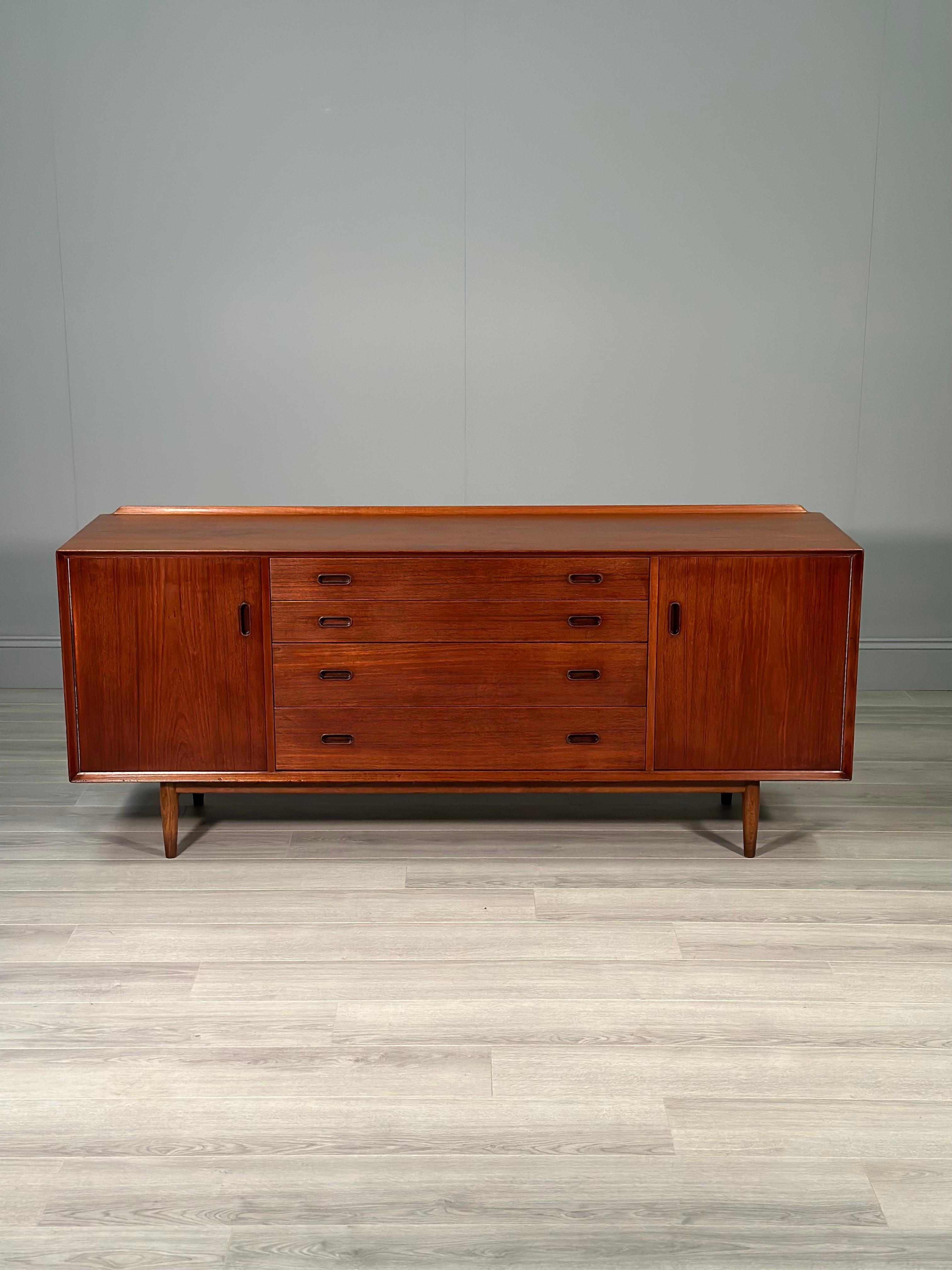 A quality Danish sideboard designed by Arne Vodder for Sibast dating 1955. Arne Vodder is one of Denmark’s top designers with this early model sideboard rarely coming to market. The sideboard consists of two side cupboards each with adjustable