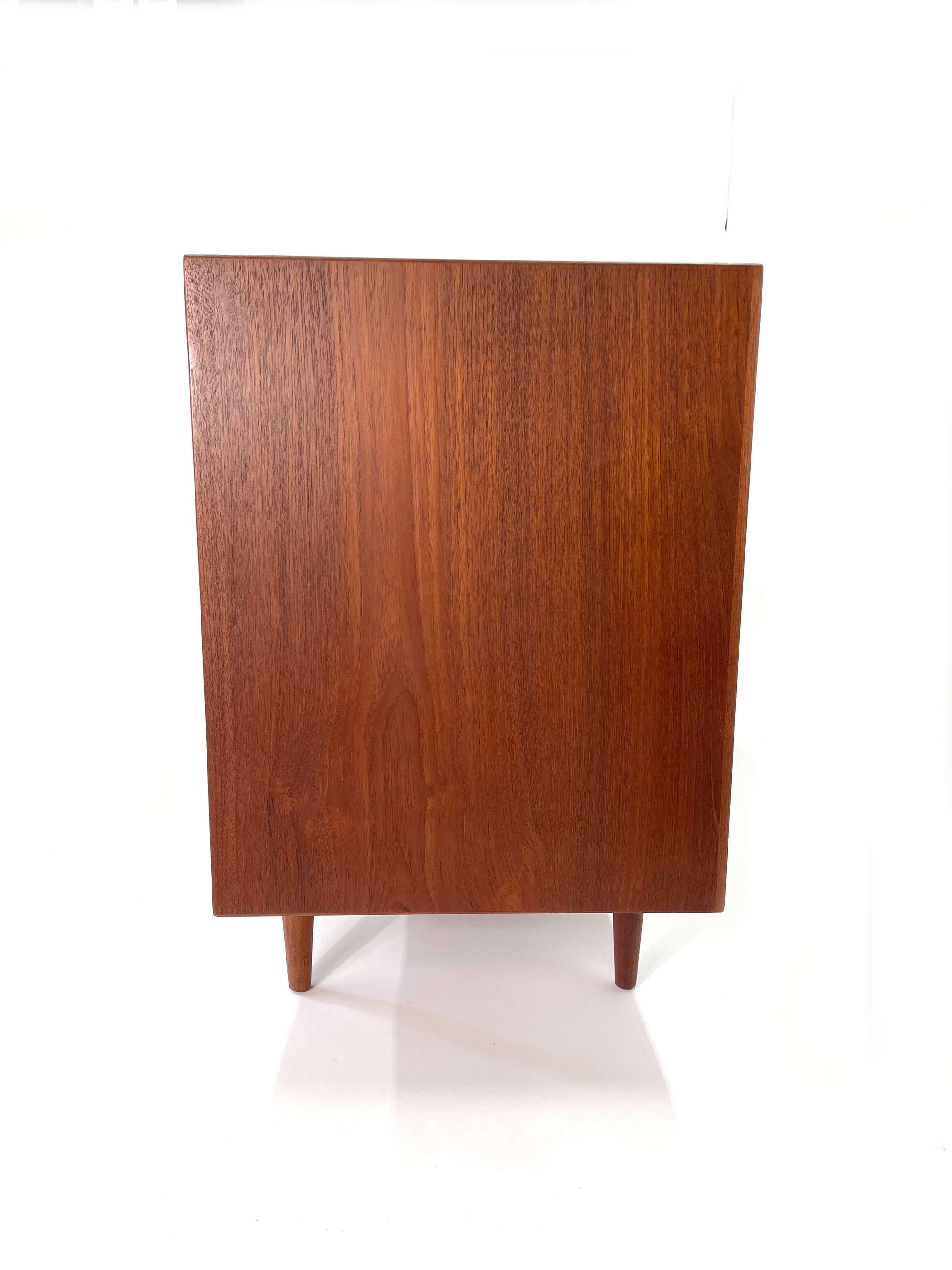 An iconic design by Arne Vodder 'Triennale' dresser was produced by Sibast Mobler, circa 1950. Constructed in teak, the long eight drawer dresser is a classic piece of danish modern furniture. The drawer faces are both architectural and functional