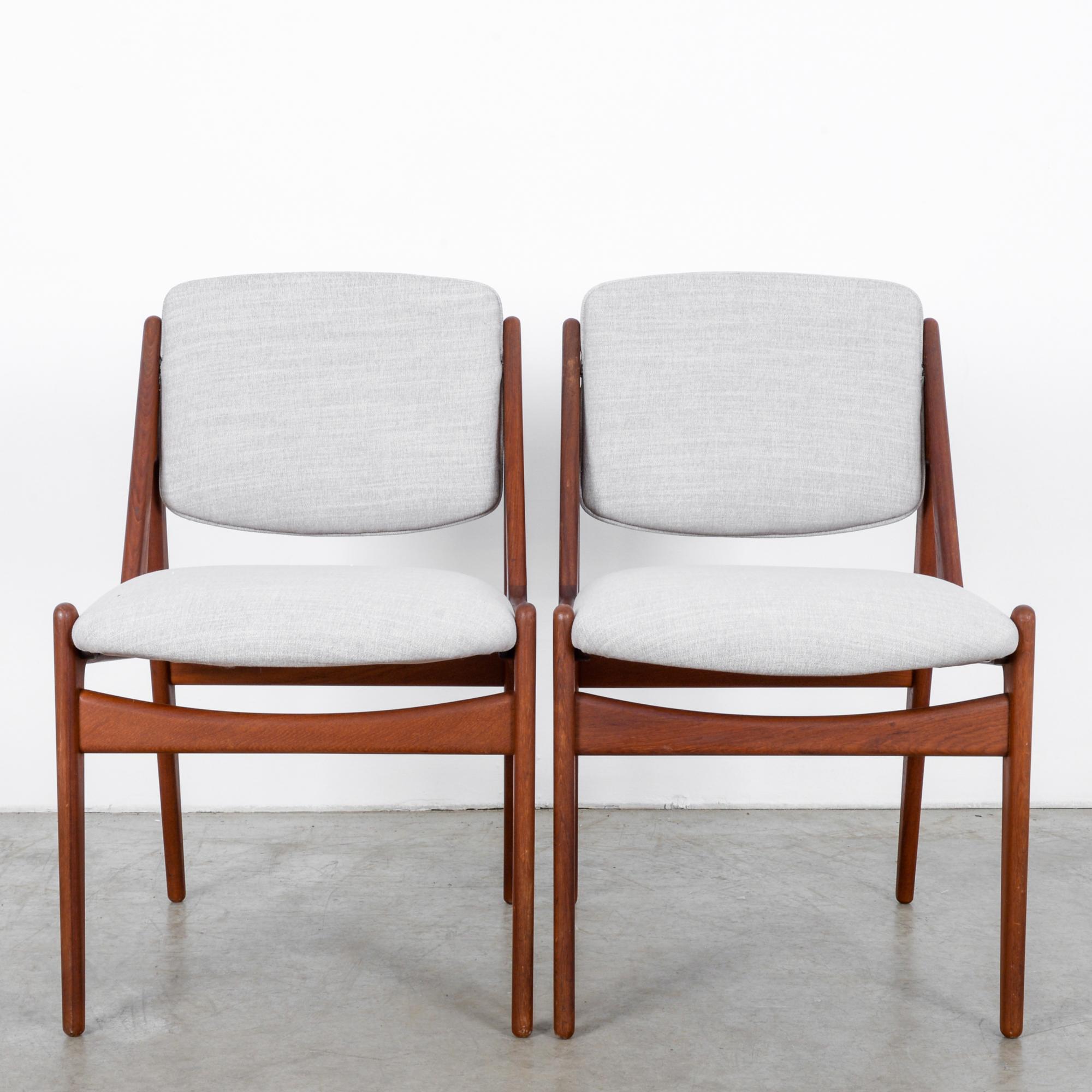 A stylish pair of wooden chairs from Danish furniture designer Arne Vodder. Vodder’s past work designing homes is on display in the architectural lines of these chairs, in the rear supports that rise up like flying buttresses, adding support and