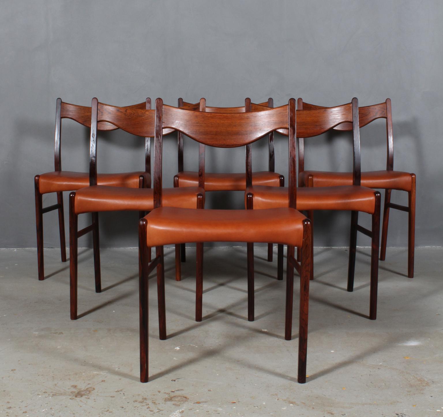 Six dining chairs designed by Arne Wahl, model GS61 for Glyngore Stolefabrik. 

Chairs crafted of solid Brazilian rosewood with new upholstered seats in cognac aniline leather.
