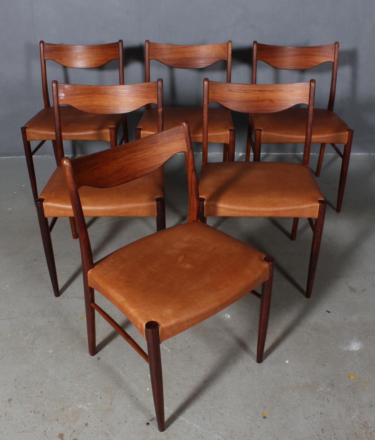 Six dining chairs designed by Arne Wahl, model GS61 for Glyngore Stolefabrik. 

Chairs crafted of solid Brazilian rosewood with new upholstered seats in cognac aniline leather.