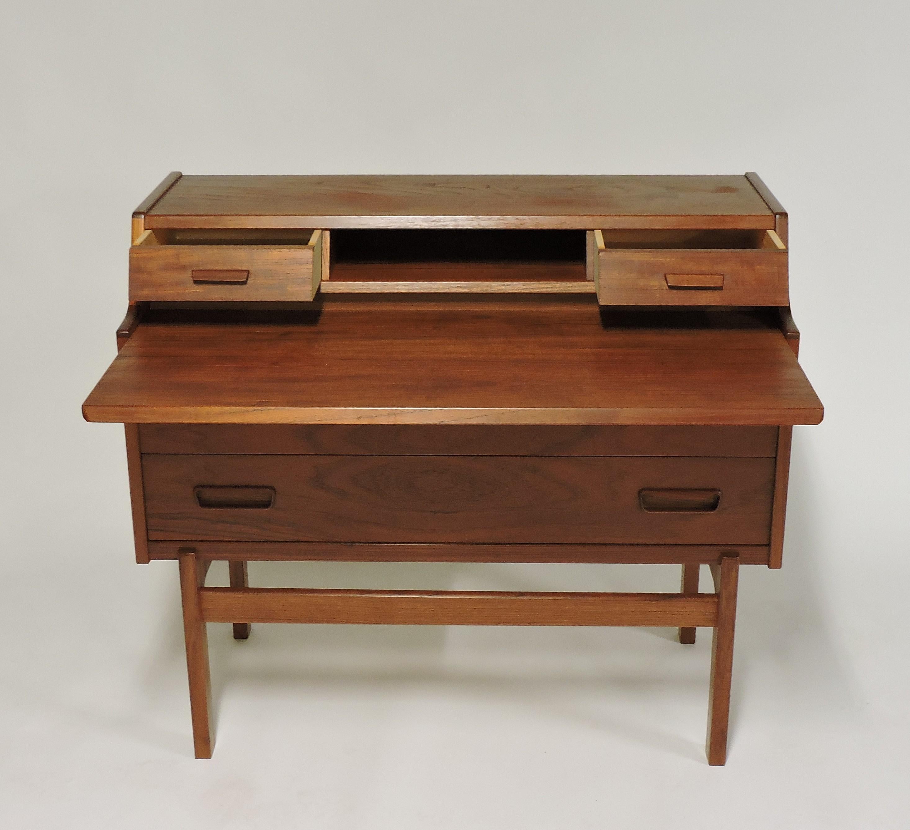 Practical and elegant teak secretary desk designed by Arne Wahl Iversen and made in Denmark by Vinde Mobelfabrik. This desk has wonderful features that include two large drawers - including one that locks - two small drawers, a cubbyhole, and a