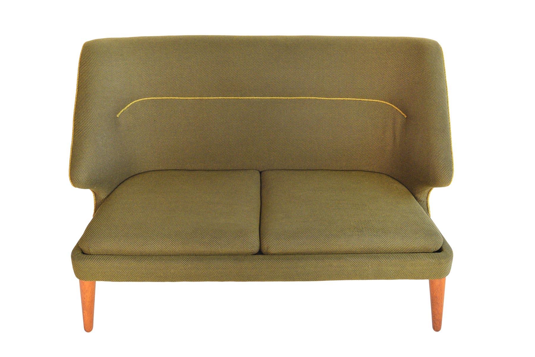 This rare Danish modern loveseat was designed by Arne Wahl Iversen as the ‘Flamingo’ sofa, Model 15, for Hans Hansen in 1955. Beautifully preserved and completely original, this cozy loveseat offers a tall back and dramatic profile. Solid canted