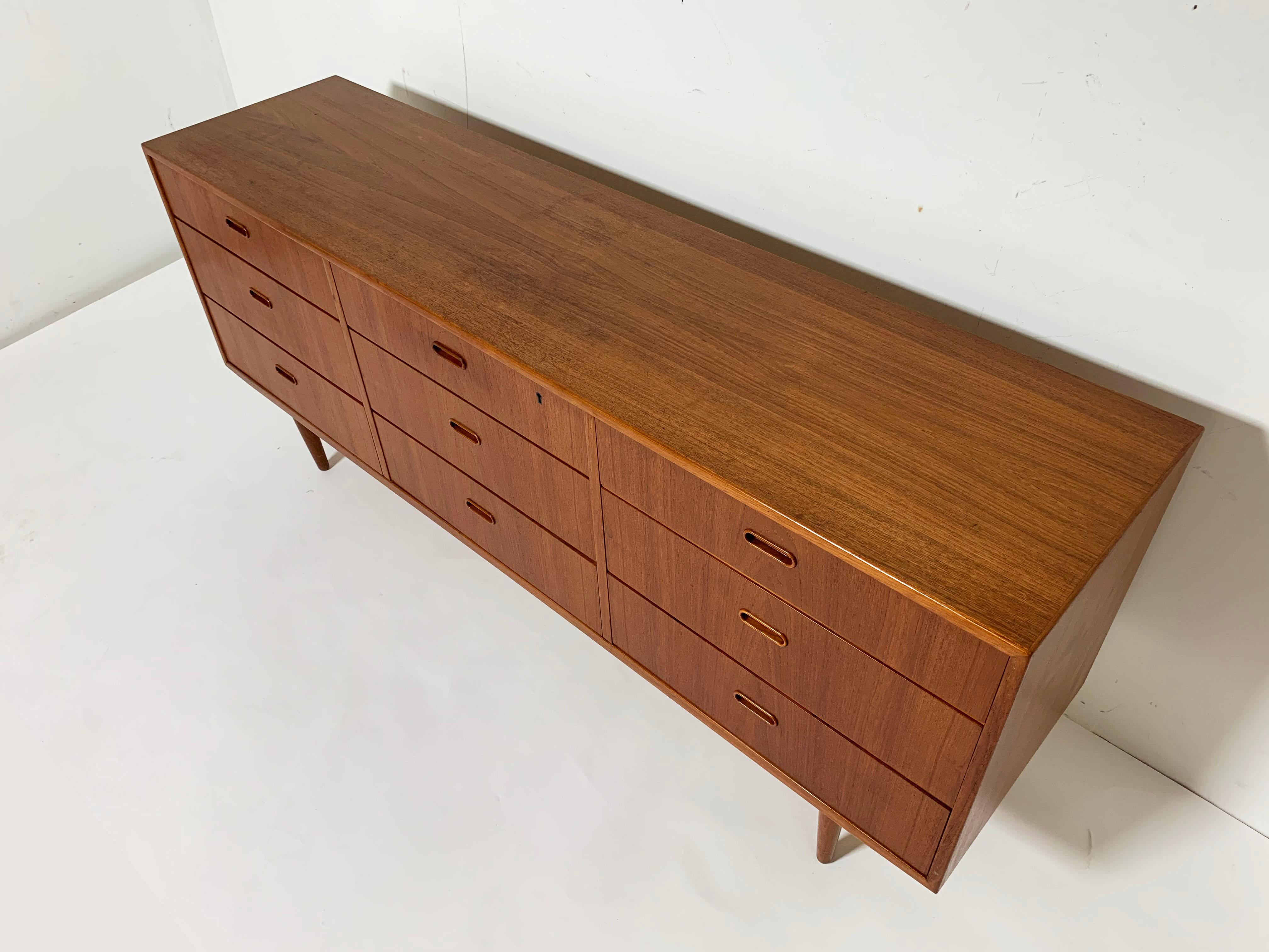 Teak nine-drawer dresser by Falster, Denmark, circa 1960s. Often attributed (erroneously, we believe) to Arne Vodder, much more likely designed by Arne Wahl Iversen, who is documented to have created other furniture with these distinctive handles