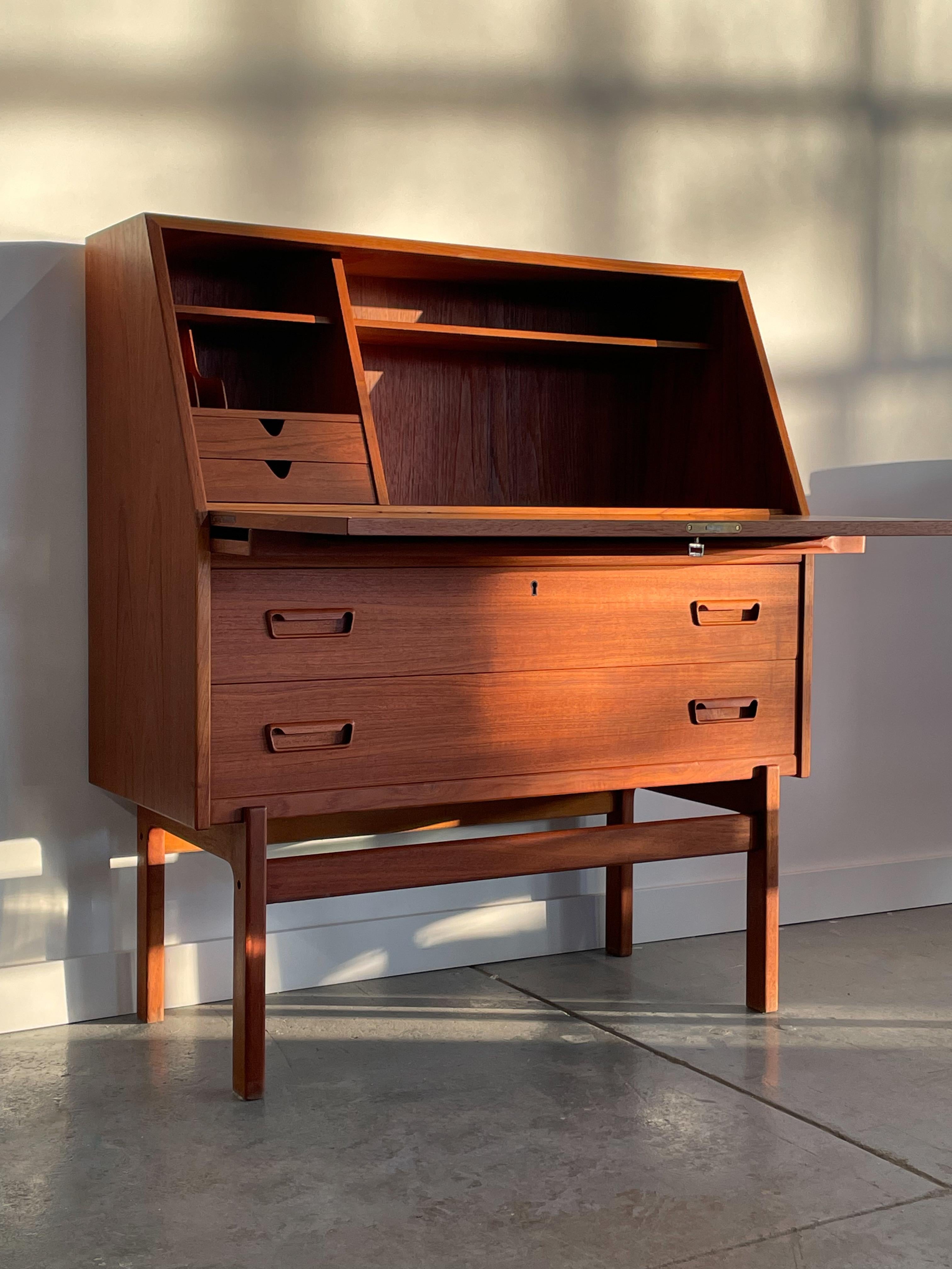 Stunning Model 68 teak drop-front secretary desk designed by Arne Wahl Iversen for Vinde Mobelfabrik, Denmark. This beautiful piece features solid construction, a drop-down writing surface, and exquisite detailing throughout including solid teak