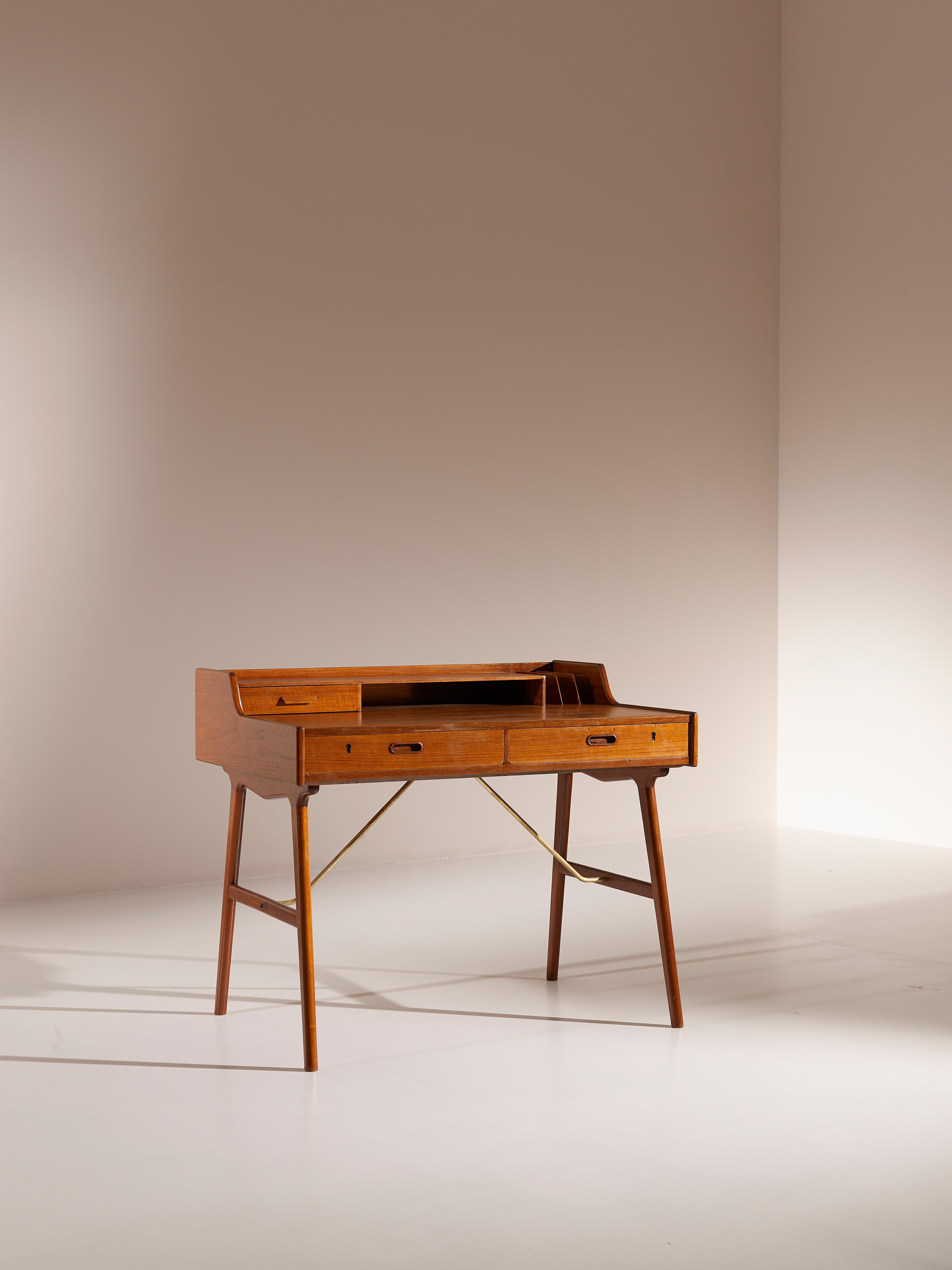 Mid century Danish writing desk model no. 56 designed by Arne Wahl Iversen for Vinde Møbelfabrik, Denmark. 

This two-tiered desk features splayed legs with supporting brass crossbars. It offers plenty of storage for organising personal belongings
